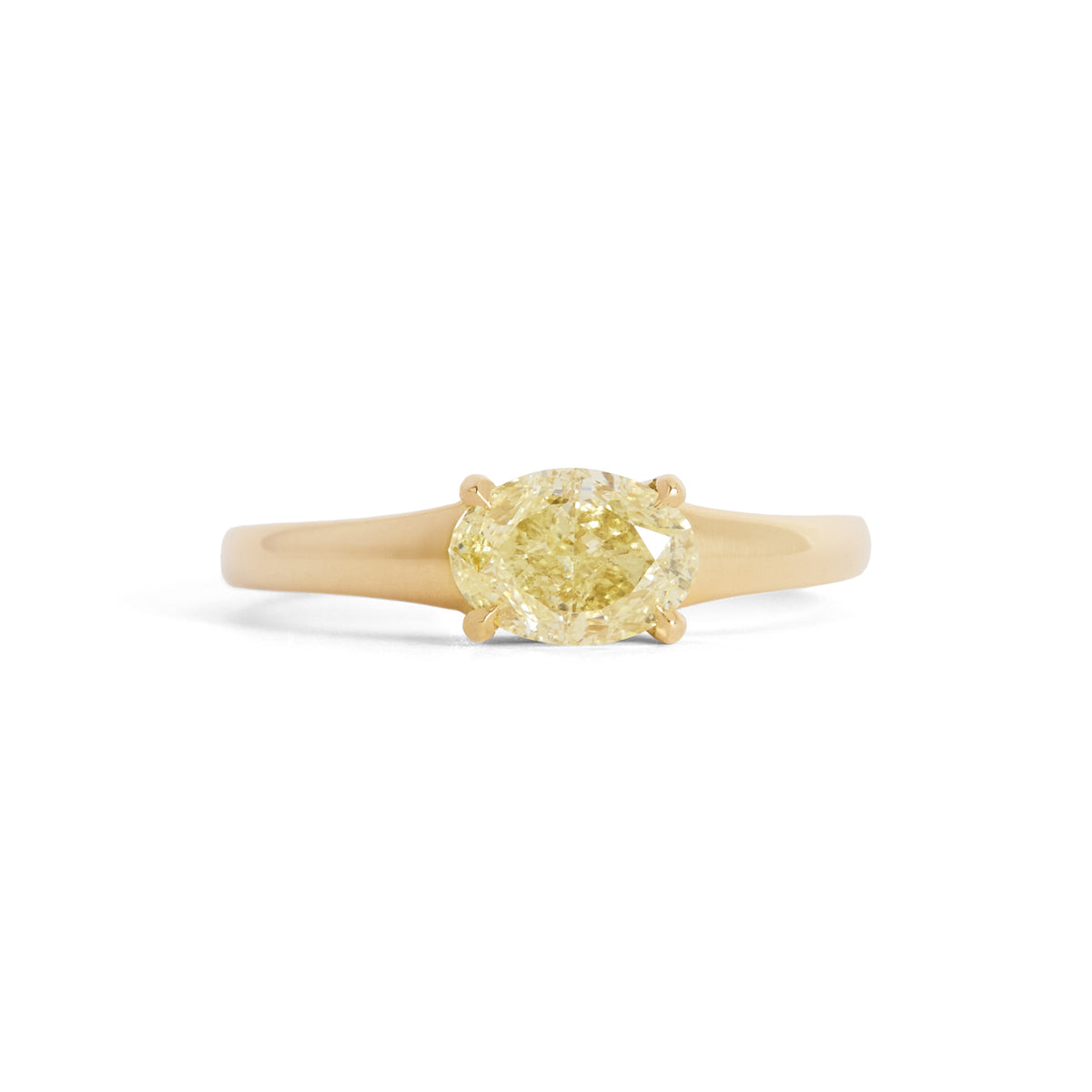 A yellow diamond solitaire ring set in a yellow gold tapered band, centered on a plain white background.