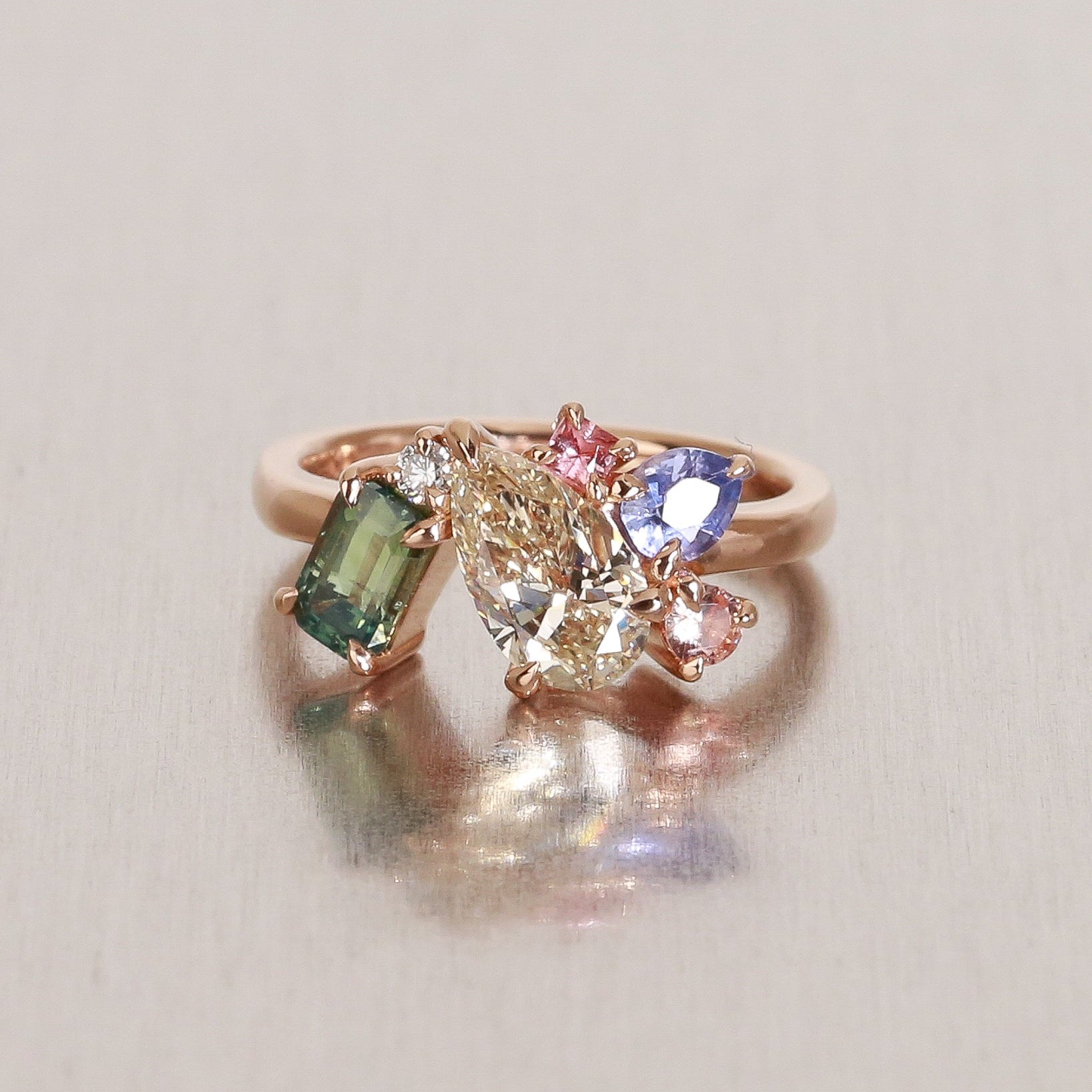 Ring with multicolored gemstones on a light gray background