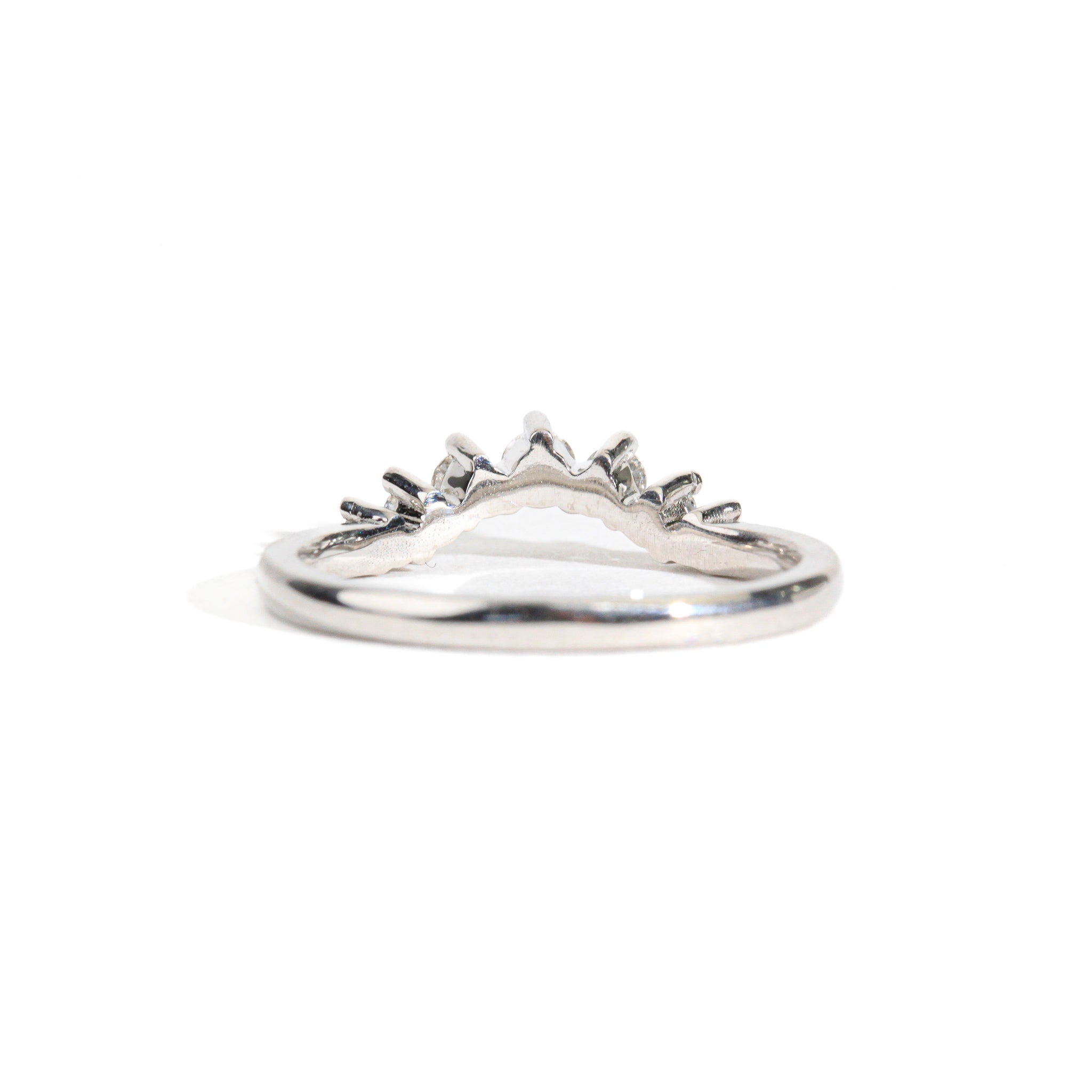 18 carat white gold woman's wedding band with 7 round white diamonds, claw set in a slight curve.