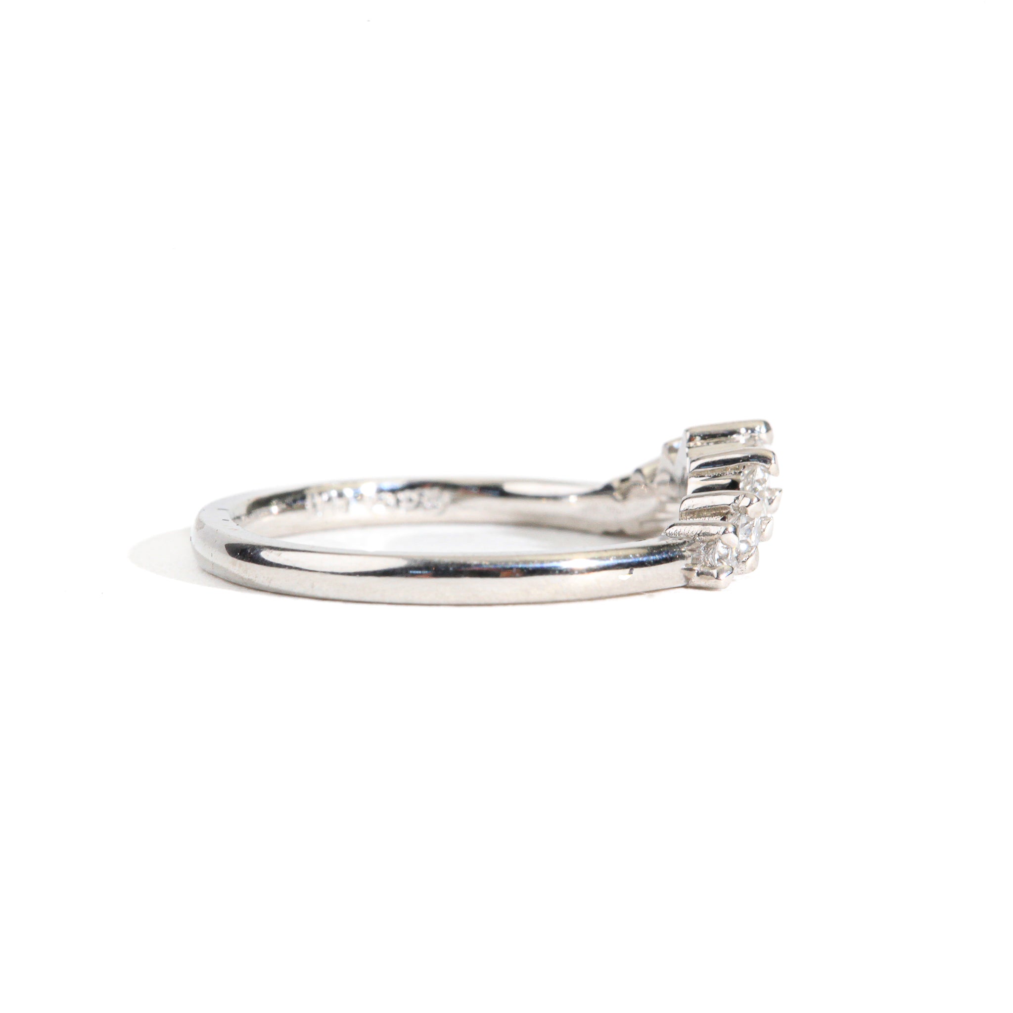 18 carat white gold woman's wedding band with 7 round white diamonds, claw set in a slight curve.