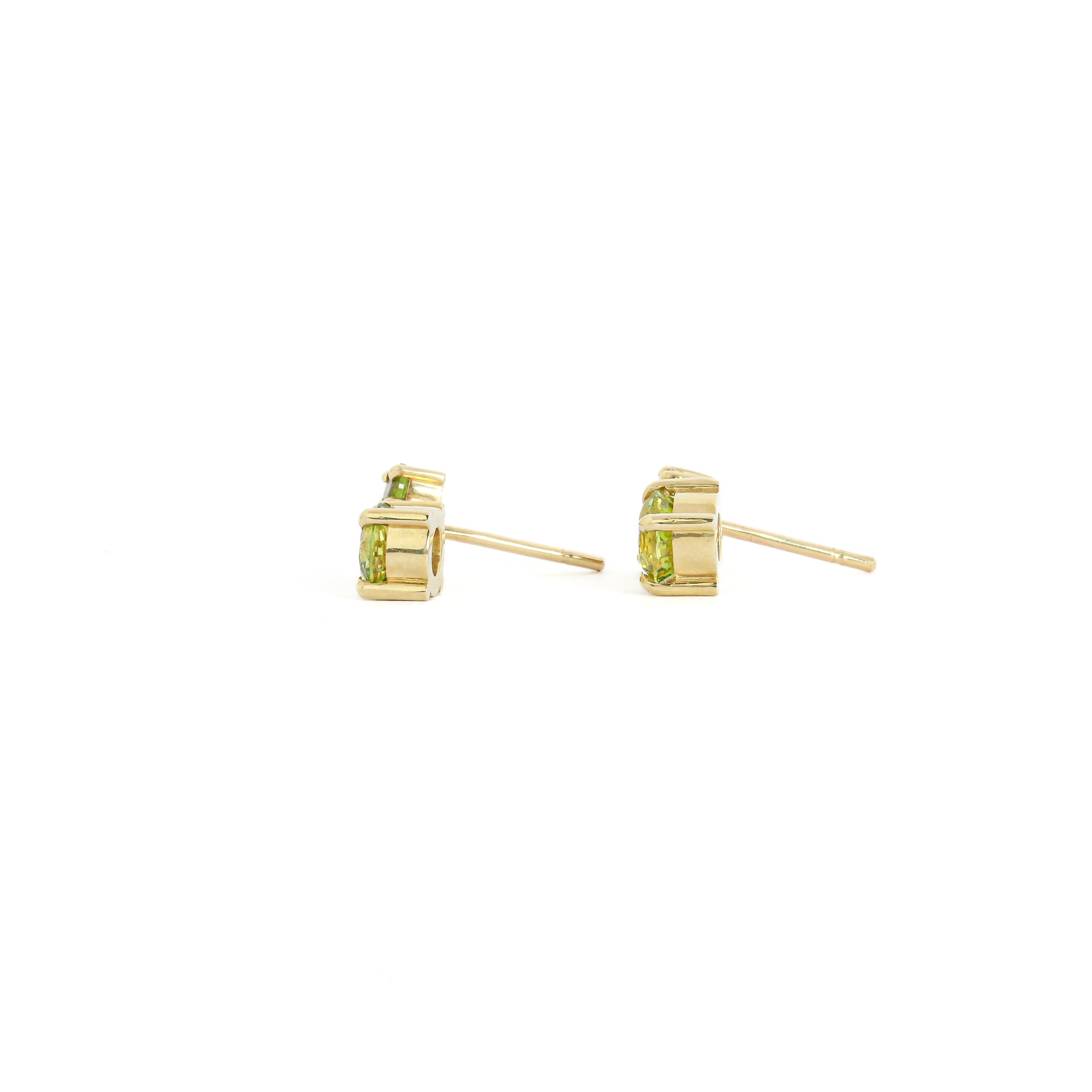 Gold stud earrings with green gemstones on a white background