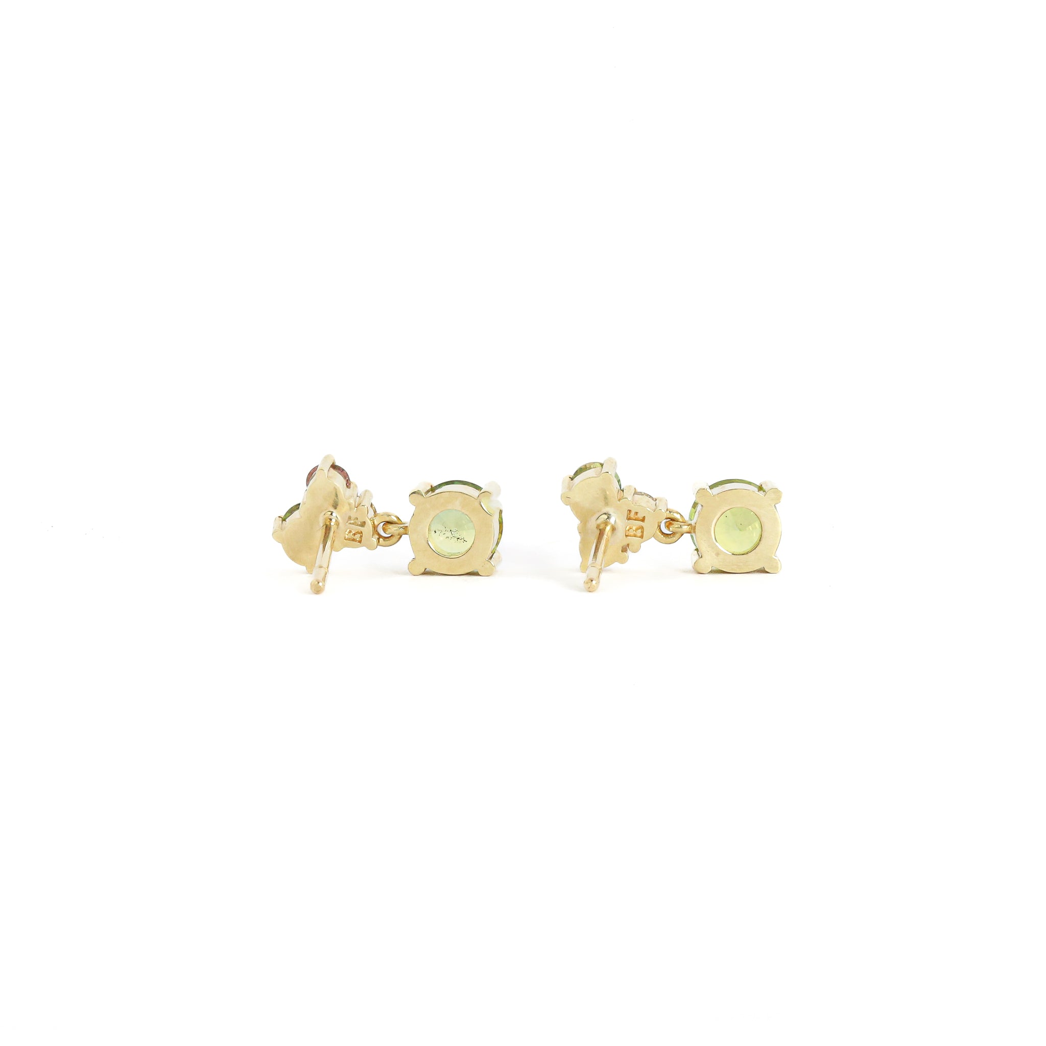 Gold earrings with a light green gemstone on a white background