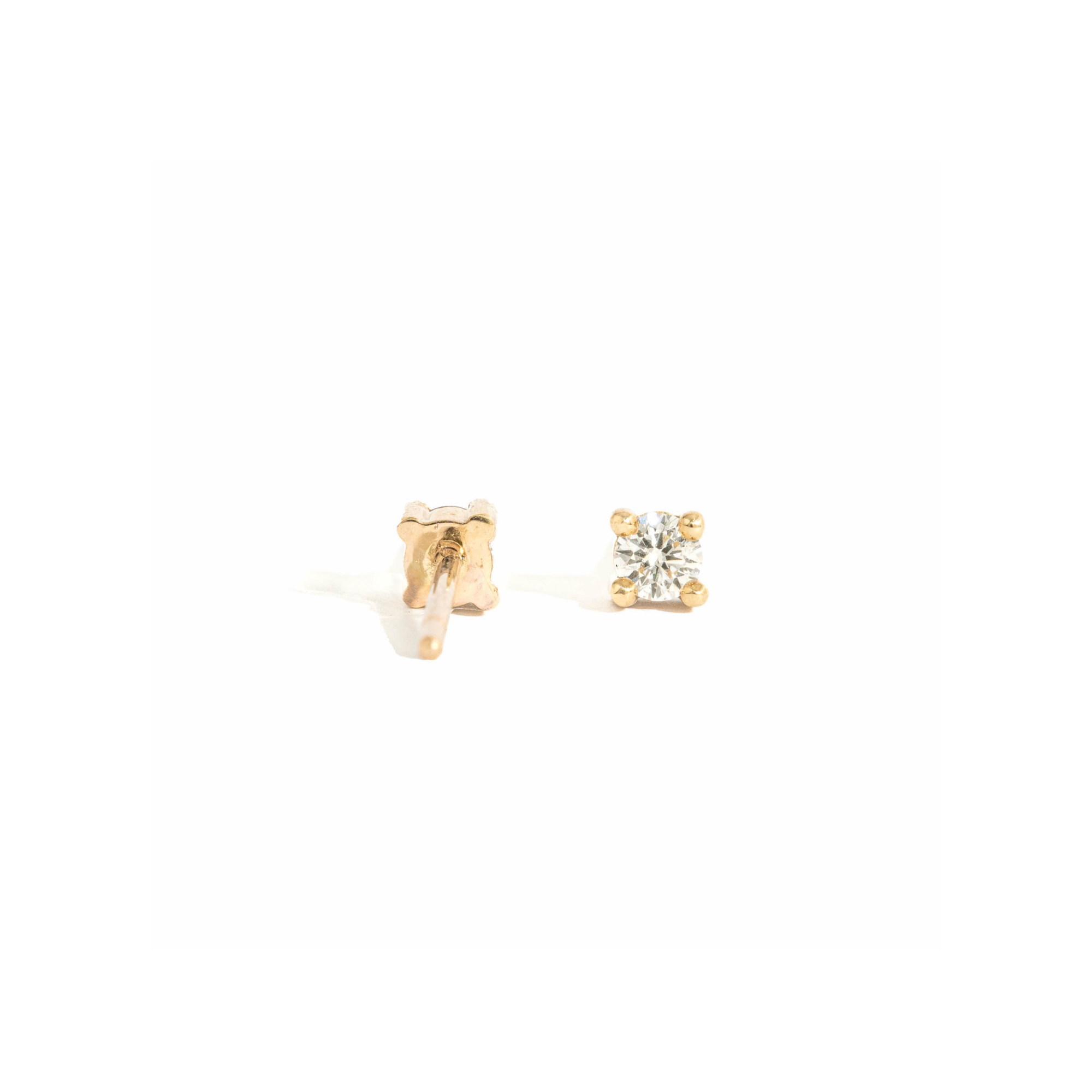 pair of white diamond stud earrings in yellow gold