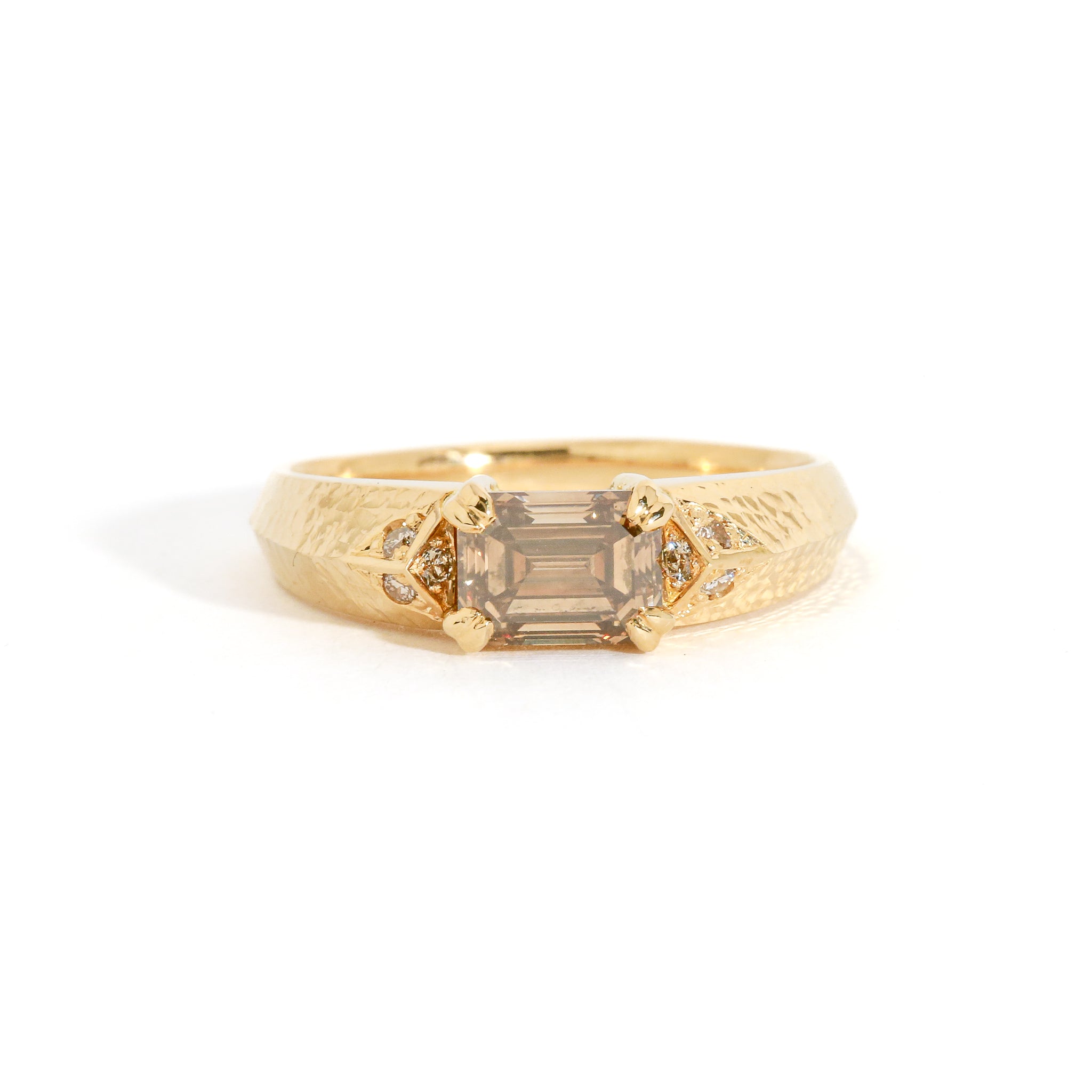 Gold ring with a cognac diamond on a white background