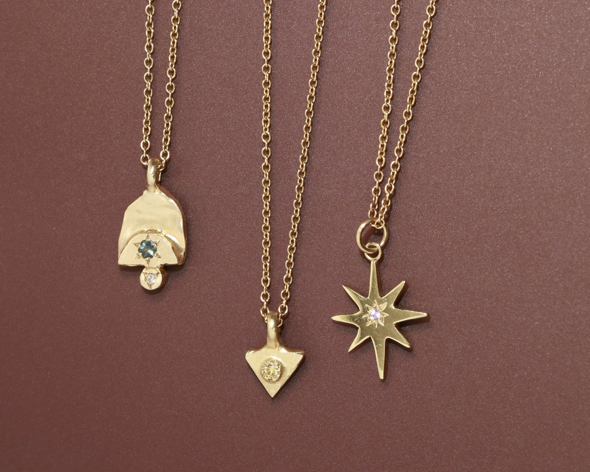 three gold pendant necklaces