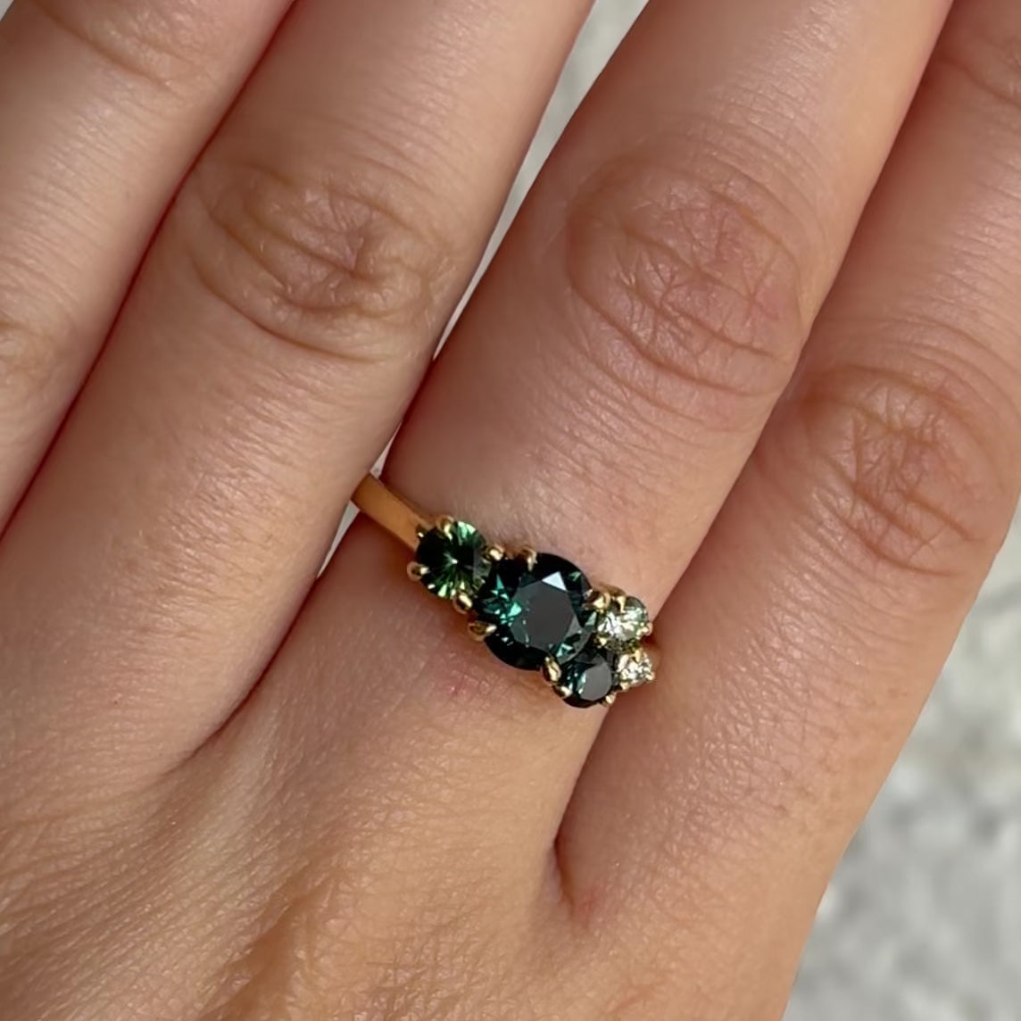 gold cluster engagement ring set with green sapphires
