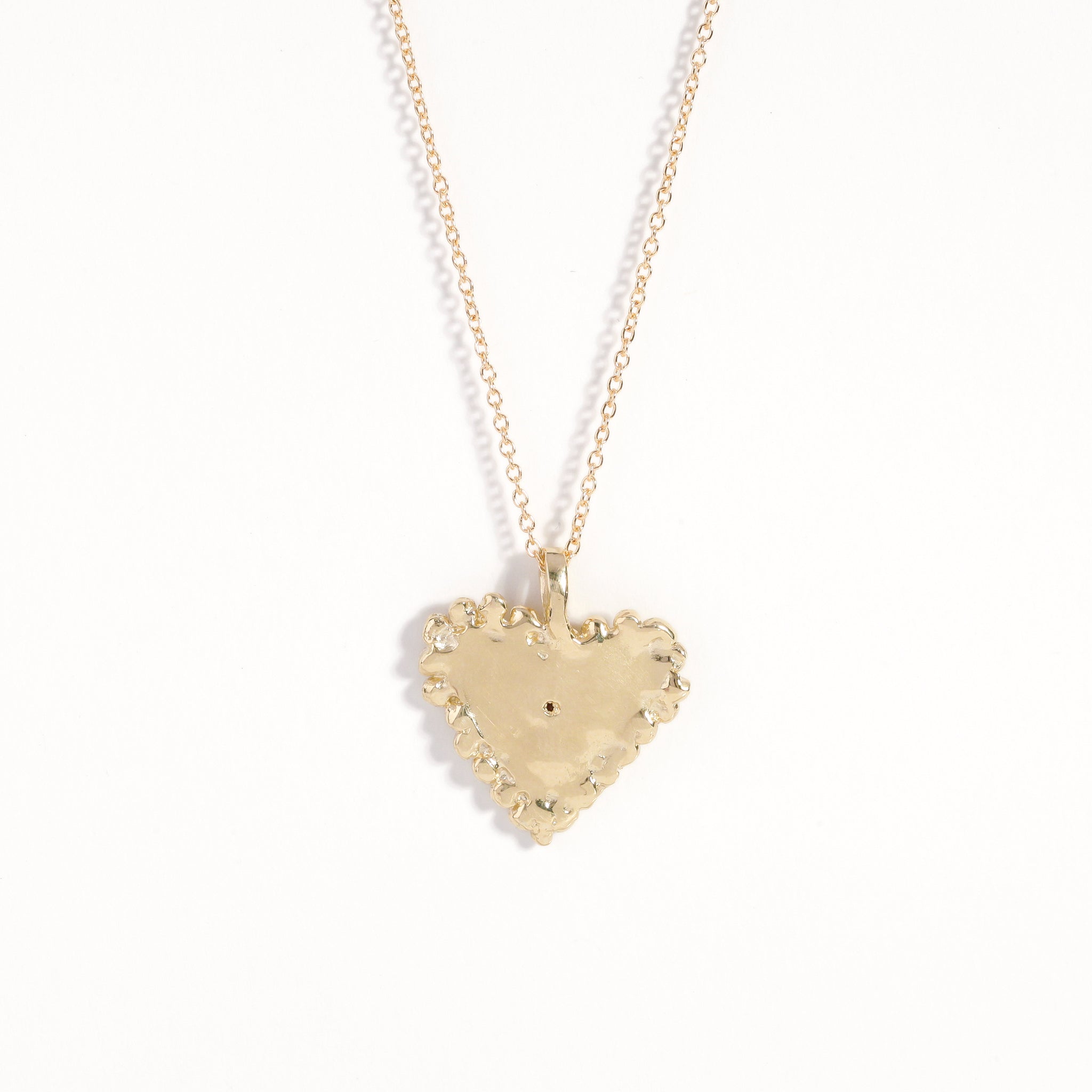 Handmade 9 carat yellow gold heart pendant set with a ruby in centre of eye detail on 9 carat yellow gold chain.