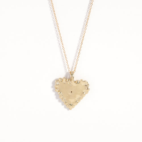 Handmade 9 carat yellow gold heart pendant set with a ruby in centre of eye detail on 9 carat yellow gold chain.