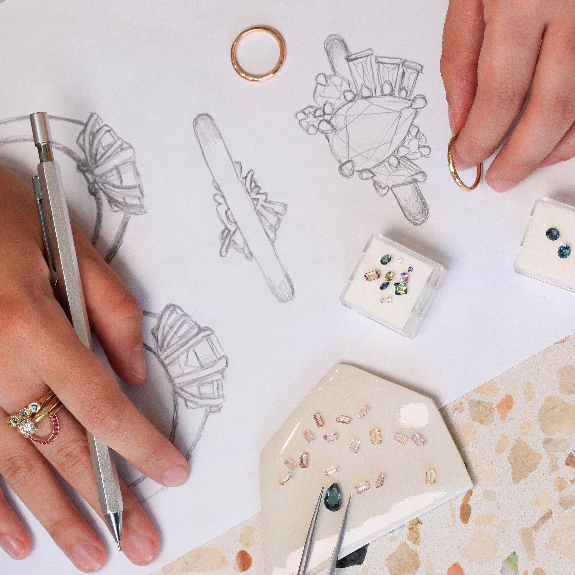 A birds-eye view of our in-store custom process, featuring sketches, jewels.