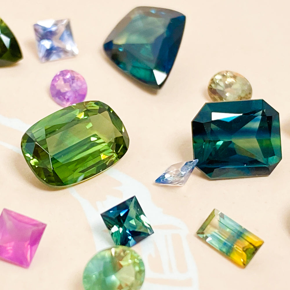 A scattering of different shapes, colours and sizes of Australian sapphires.