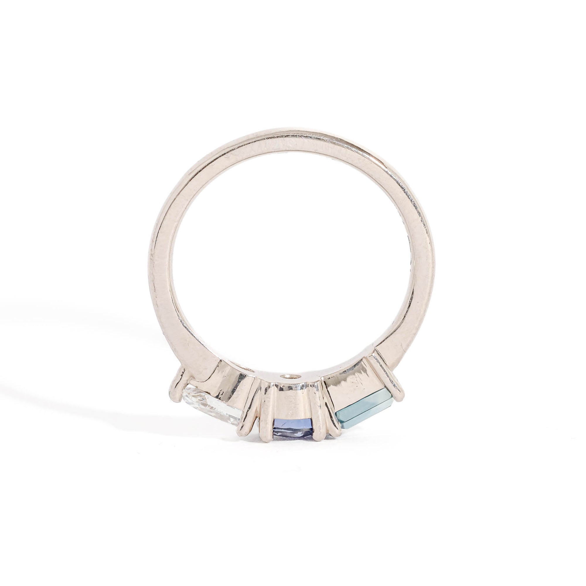 Three Stone Ring with Centre Blue Sapphire, Round White Diamond and Tapered Blue Baguette Sapphire Side Stones in 18 Carat White Gold