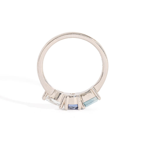 Three Stone Ring with Centre Blue Sapphire, Round White Diamond and Tapered Blue Baguette Sapphire Side Stones in 18 Carat White Gold