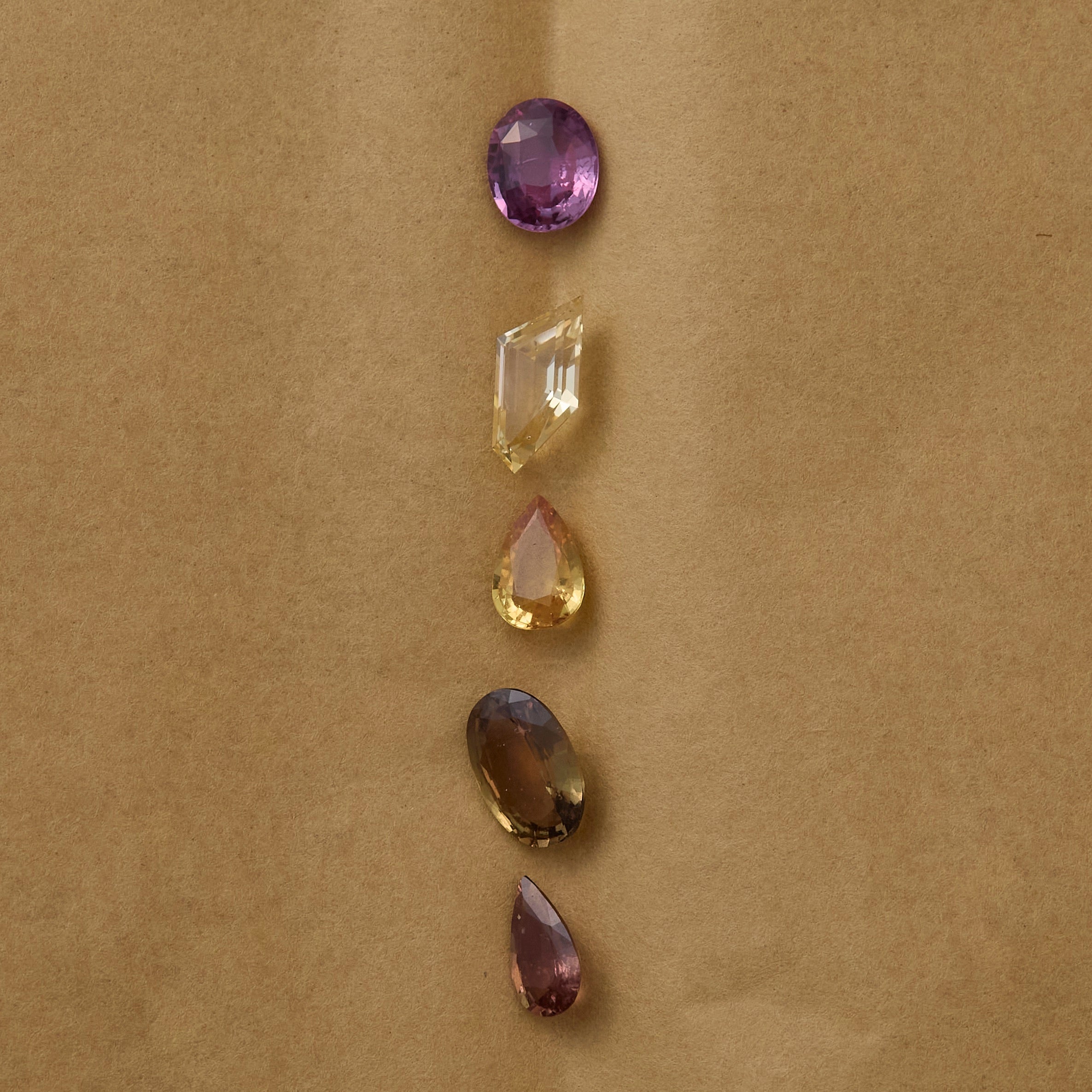 various pink and orange sapphires on brown background