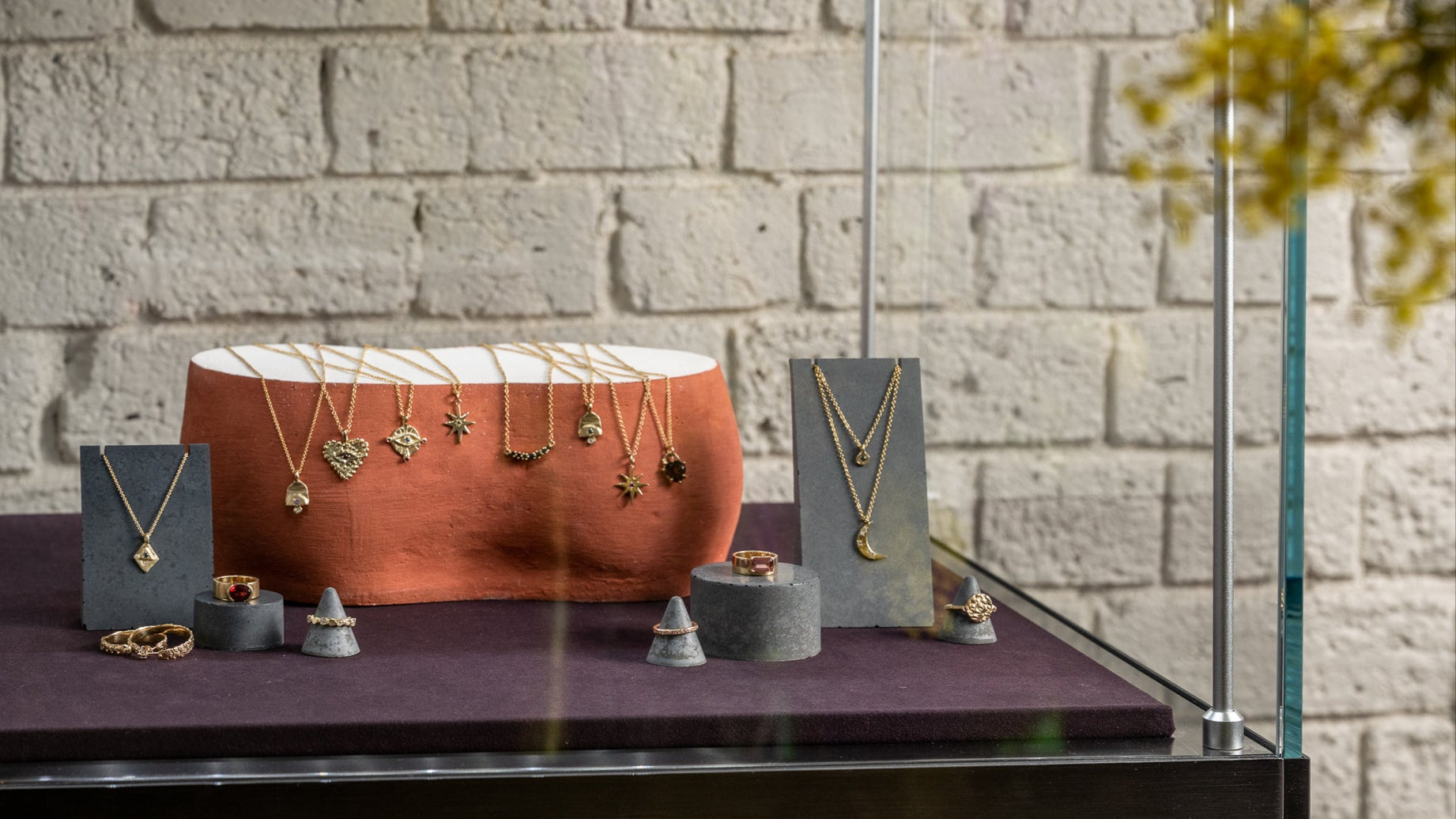 Jewelry display case with necklaces on a brick wall background