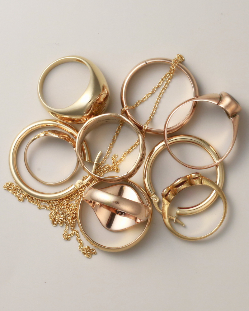 Collection of gold and rose gold jewelry on a light gray background