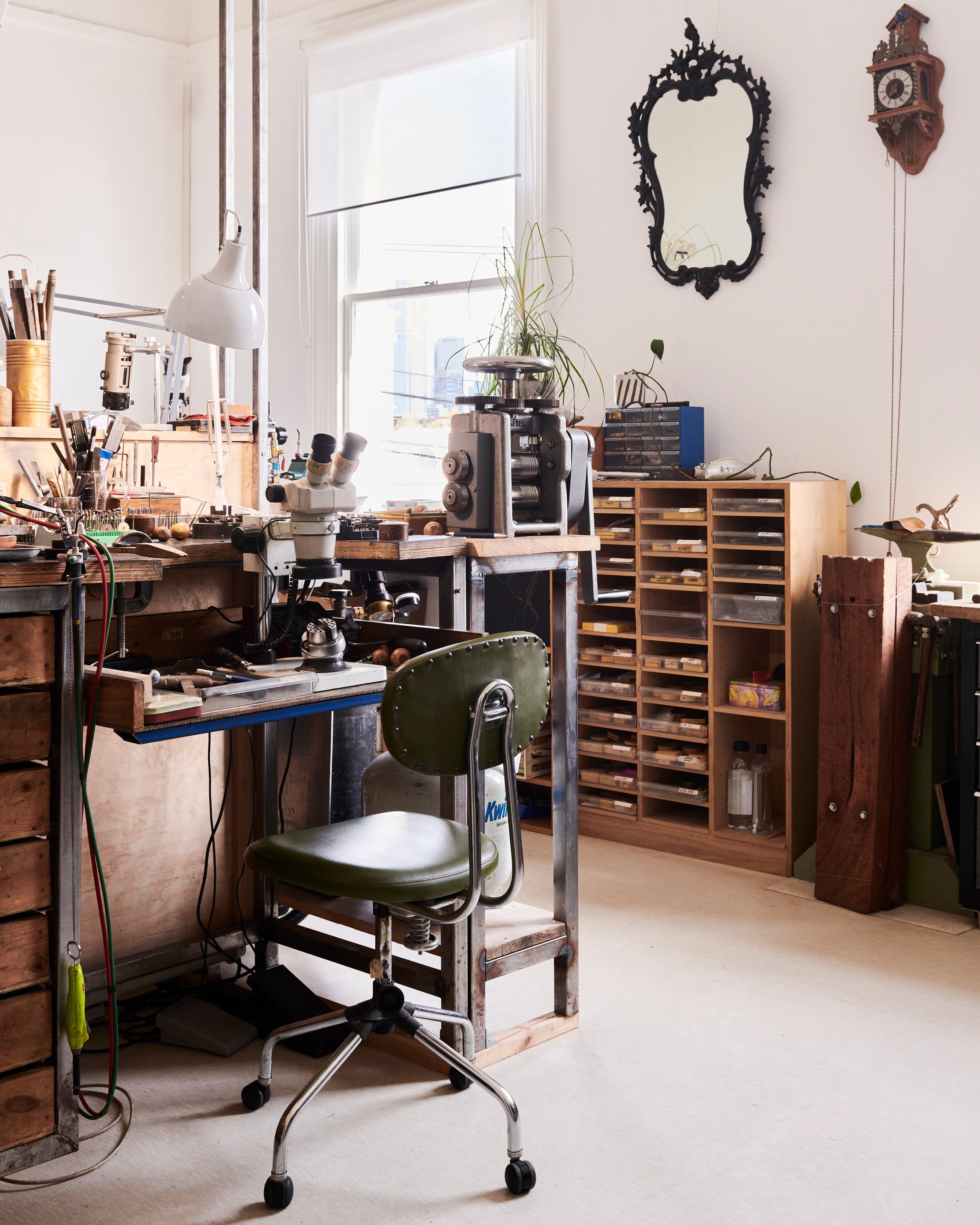 Workshop or studio with vintage furniture, tools, and a large mirror on the wall.