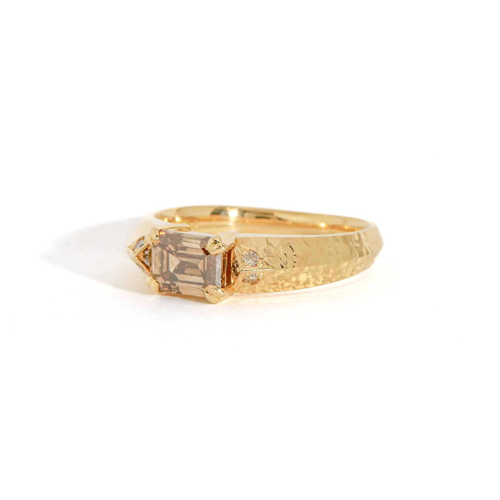 Gold ring with a cognac diamond on a white background