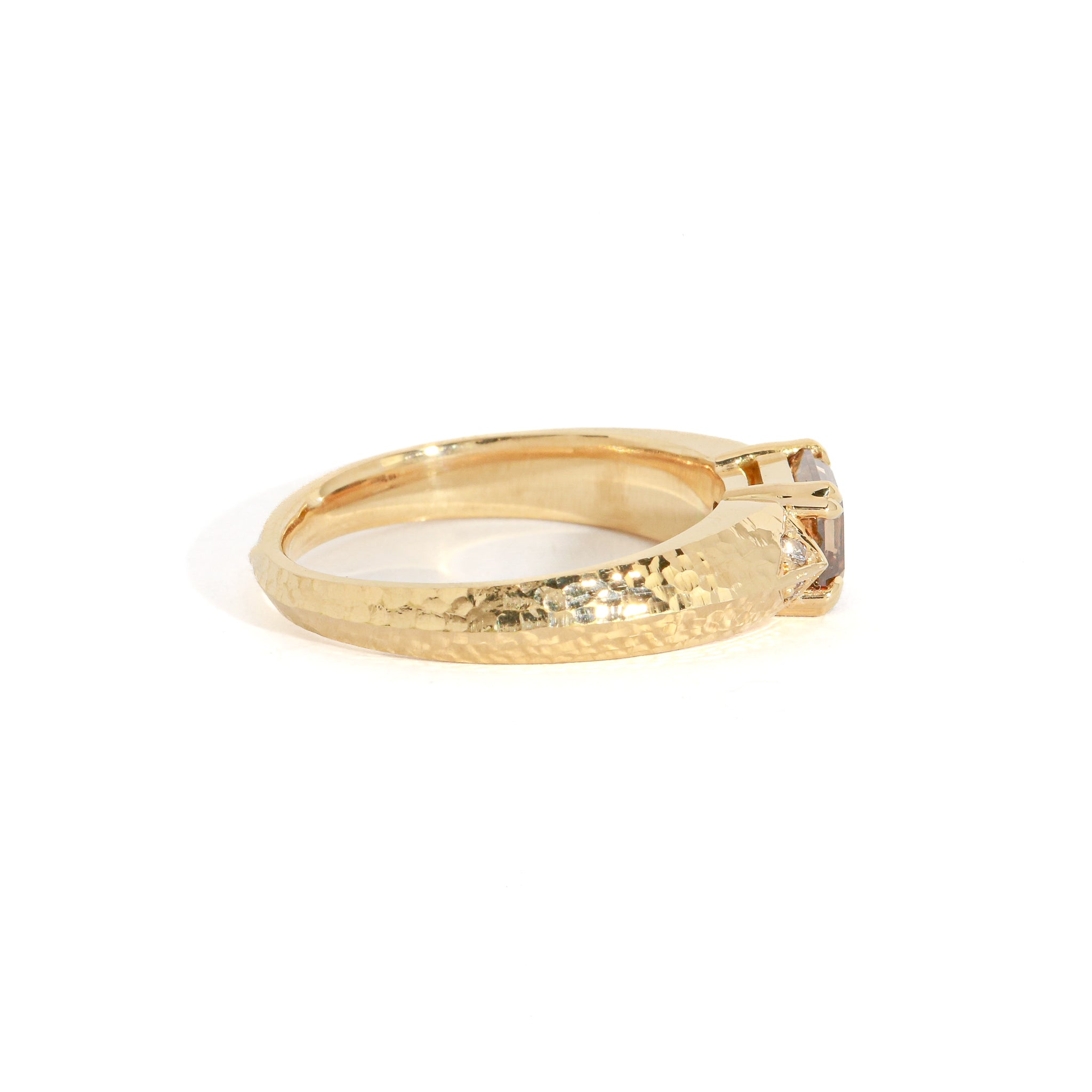 Gold ring with a cognac diamond on a white background