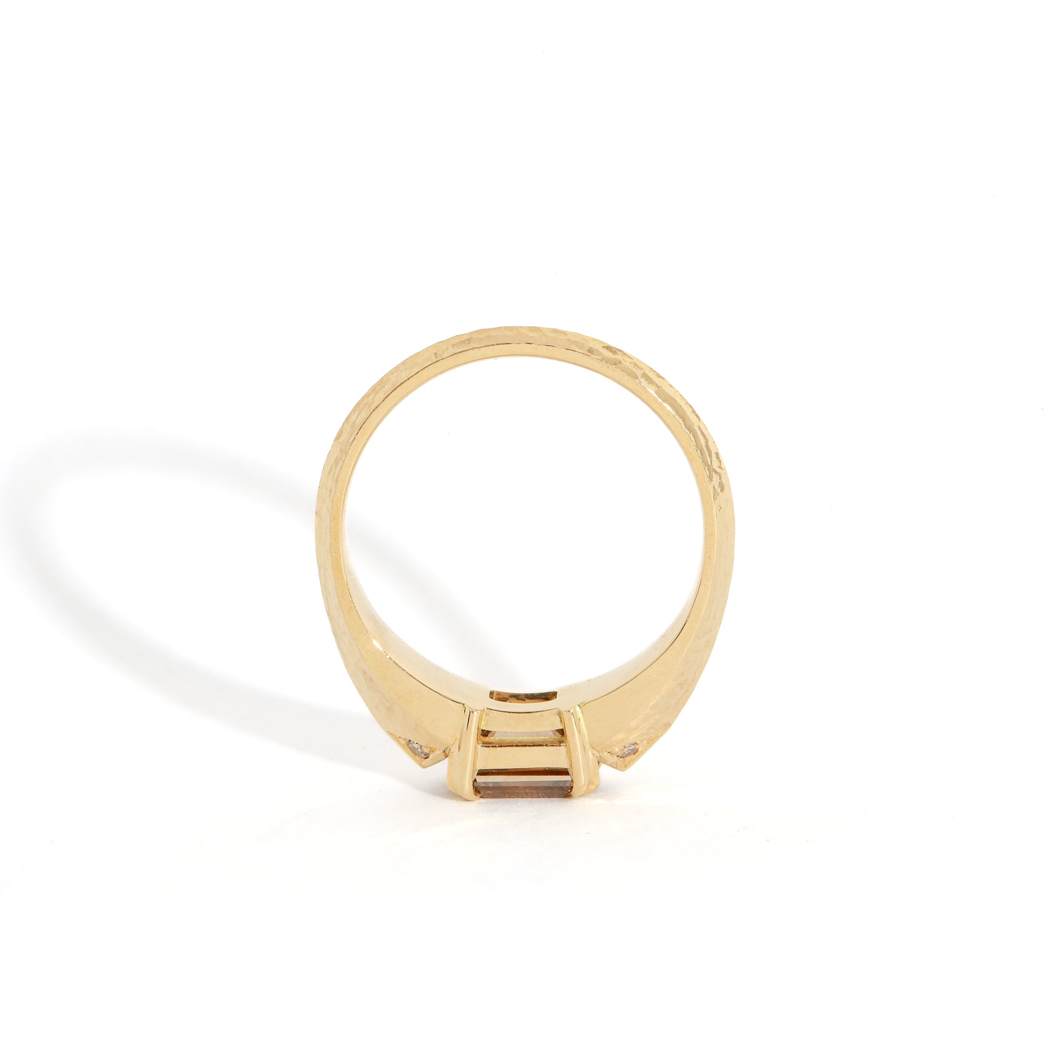 Gold ring with a cognac diamond on a white background