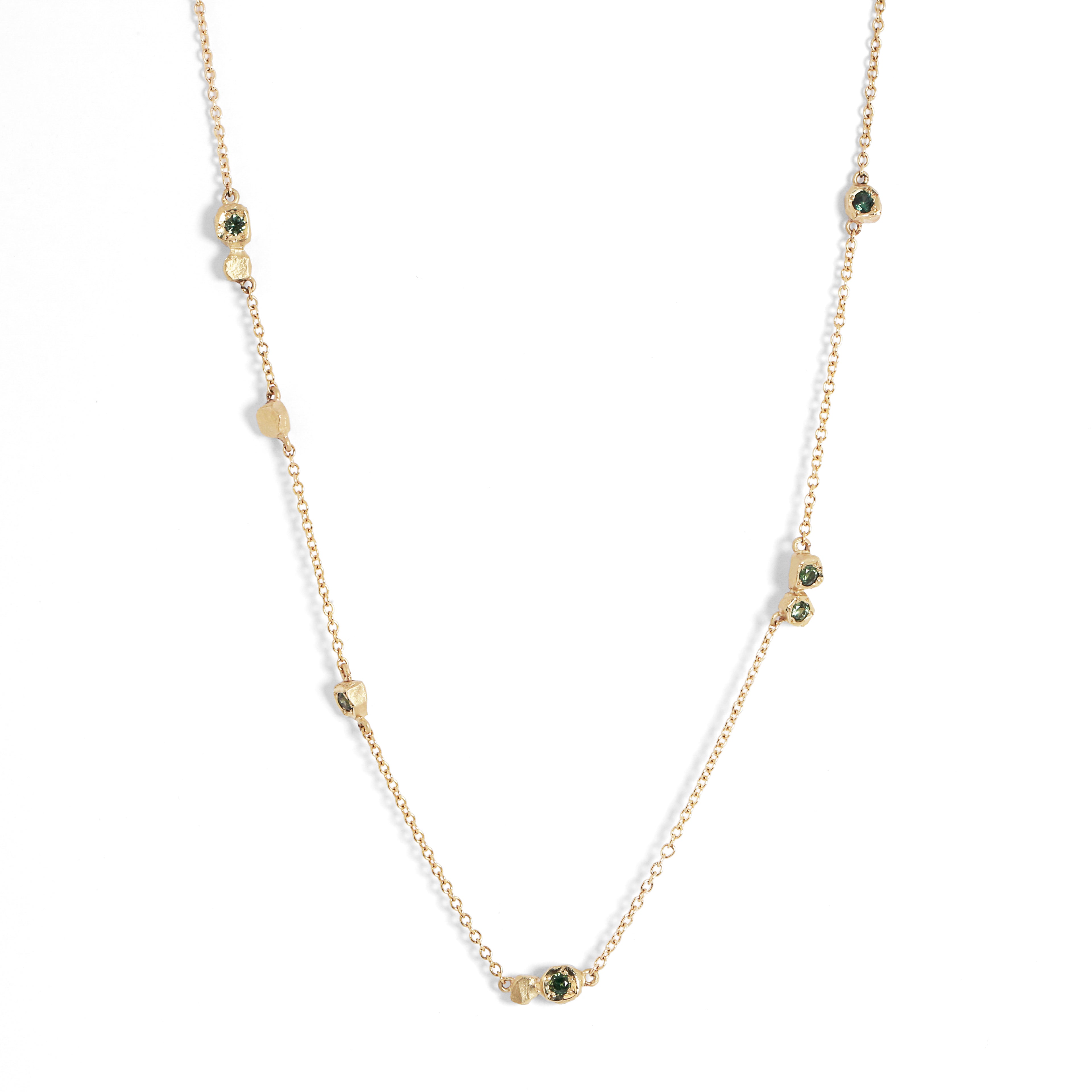Gold necklace with green gemstones on a white background