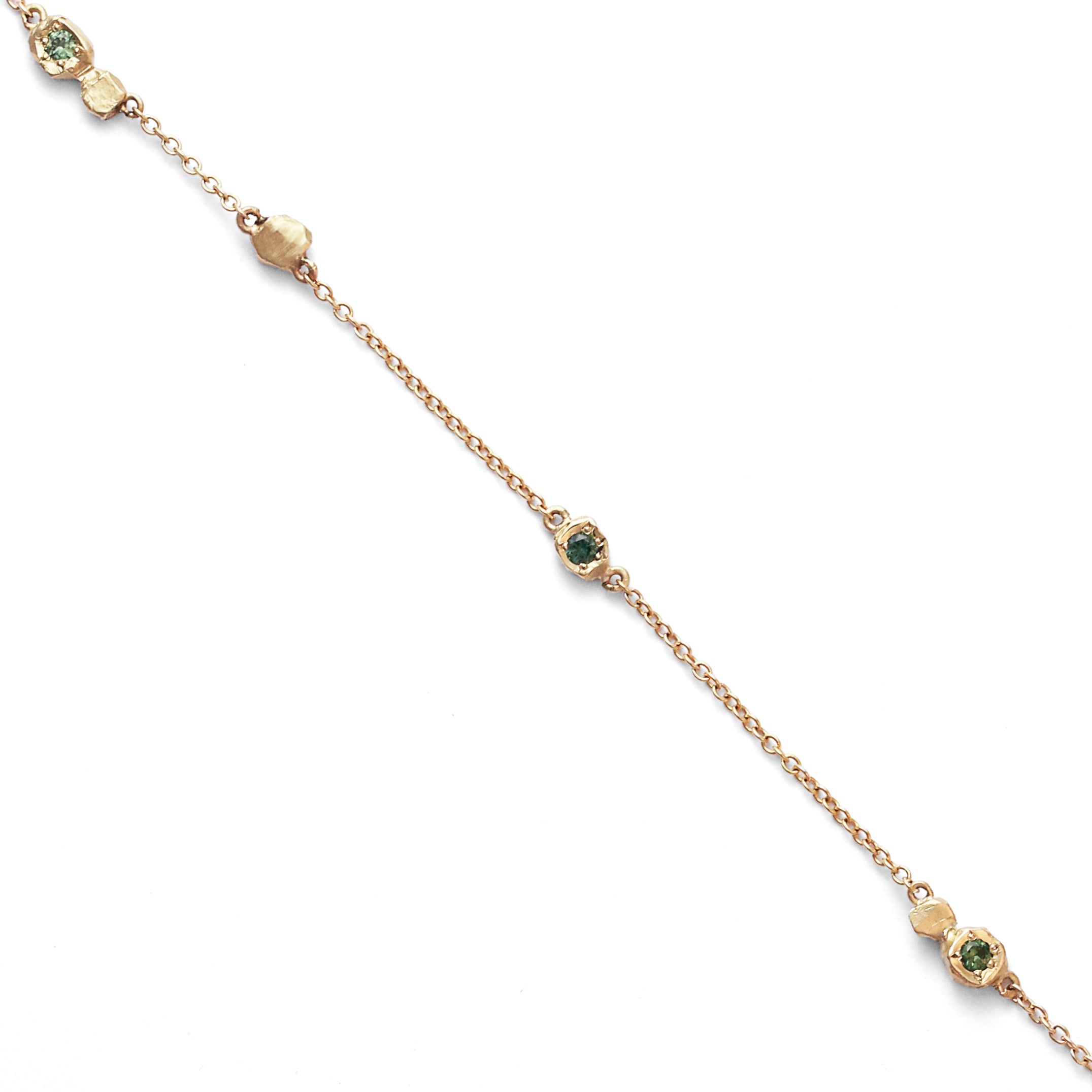 Gold necklace with green gemstones on a white background