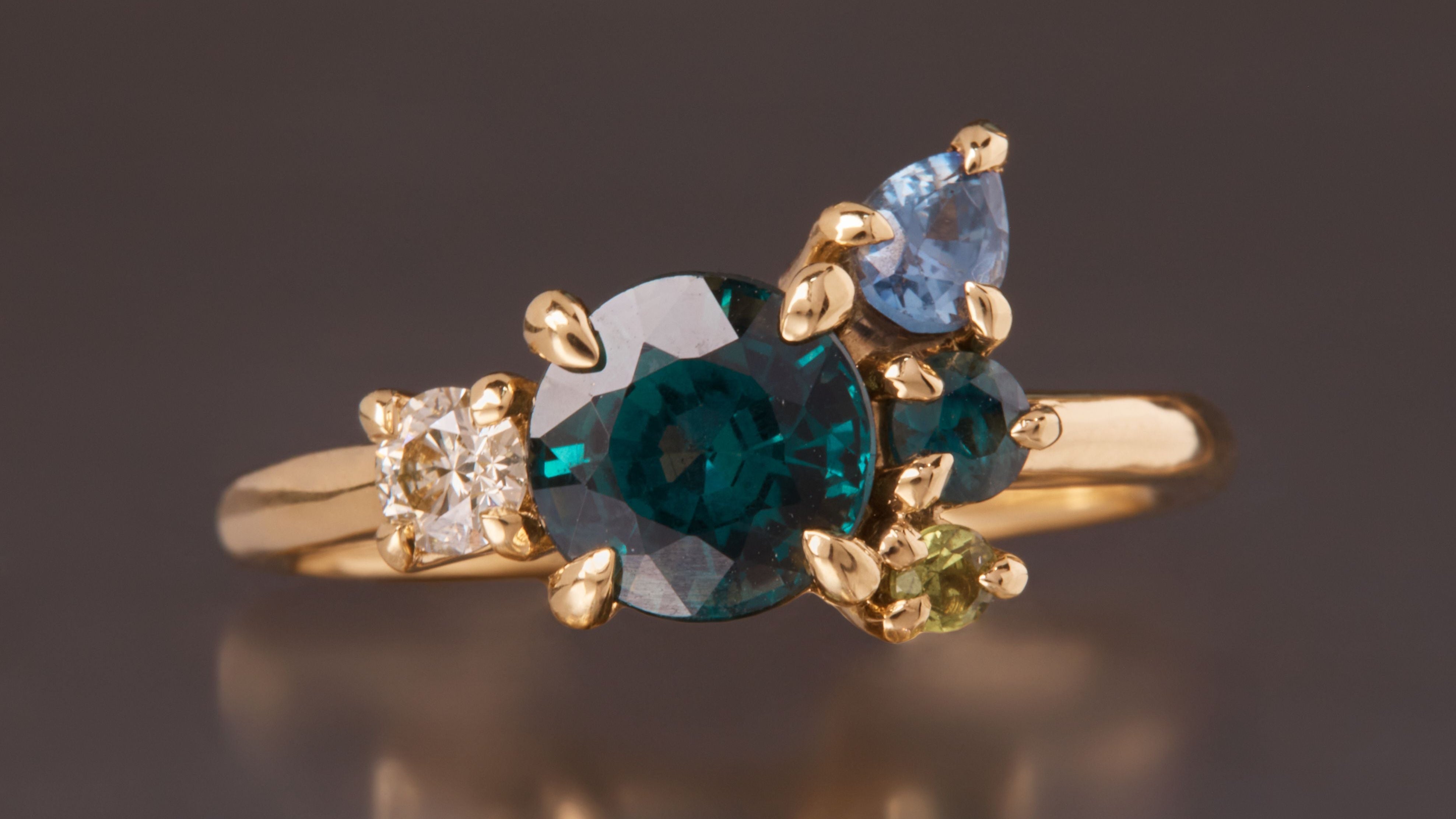 teal sapphire cluster ring in yellow gold