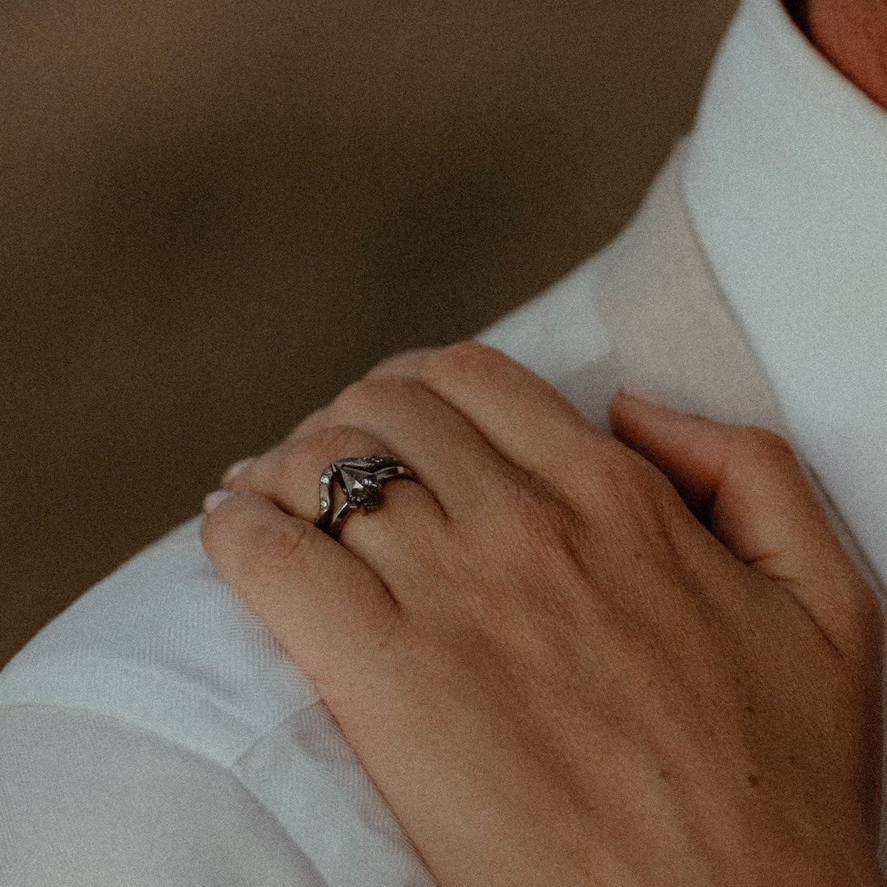Close-up of a hand wearing a ring on a blurred background