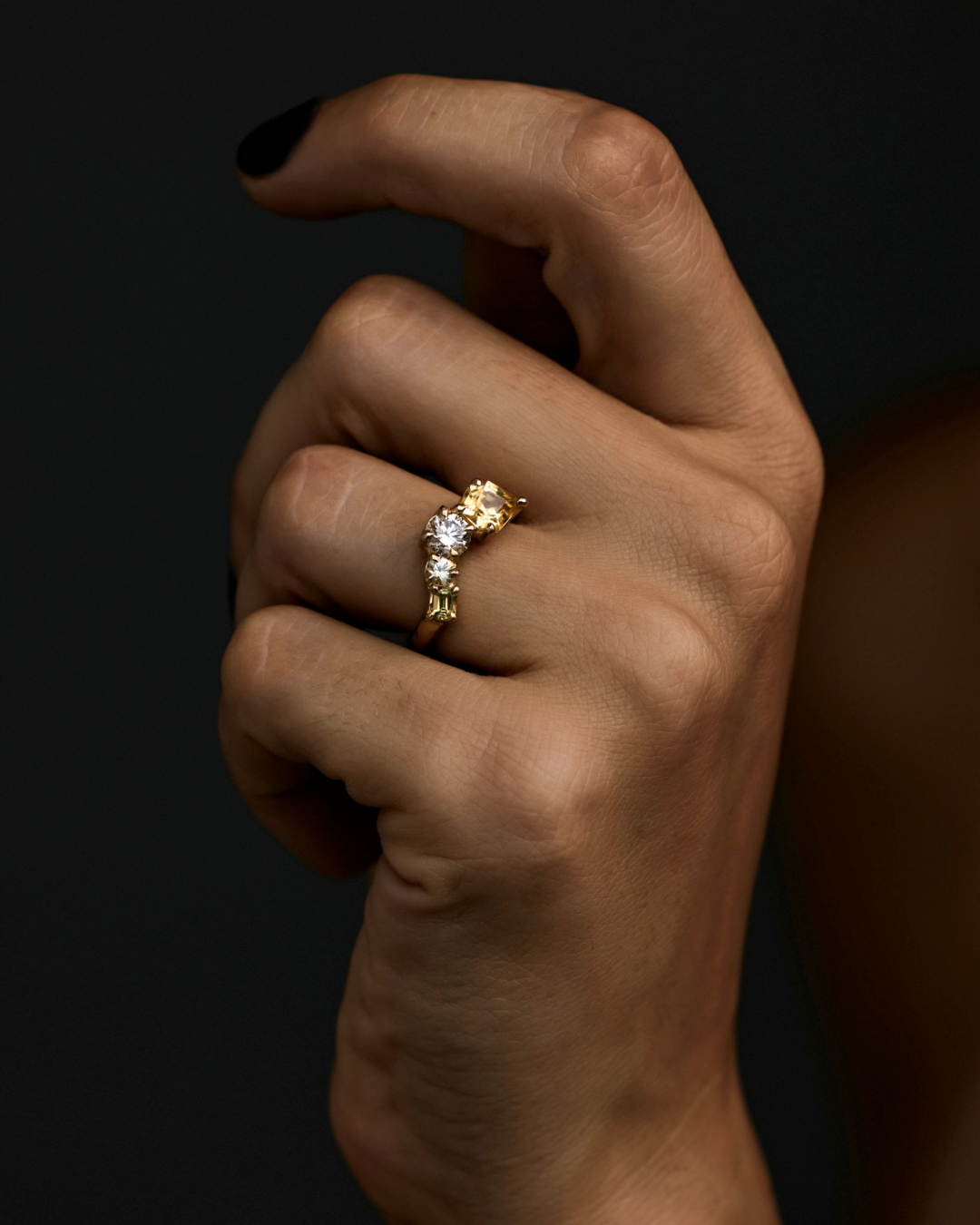arched sapphire and champagne diamond cluster ring on a hand