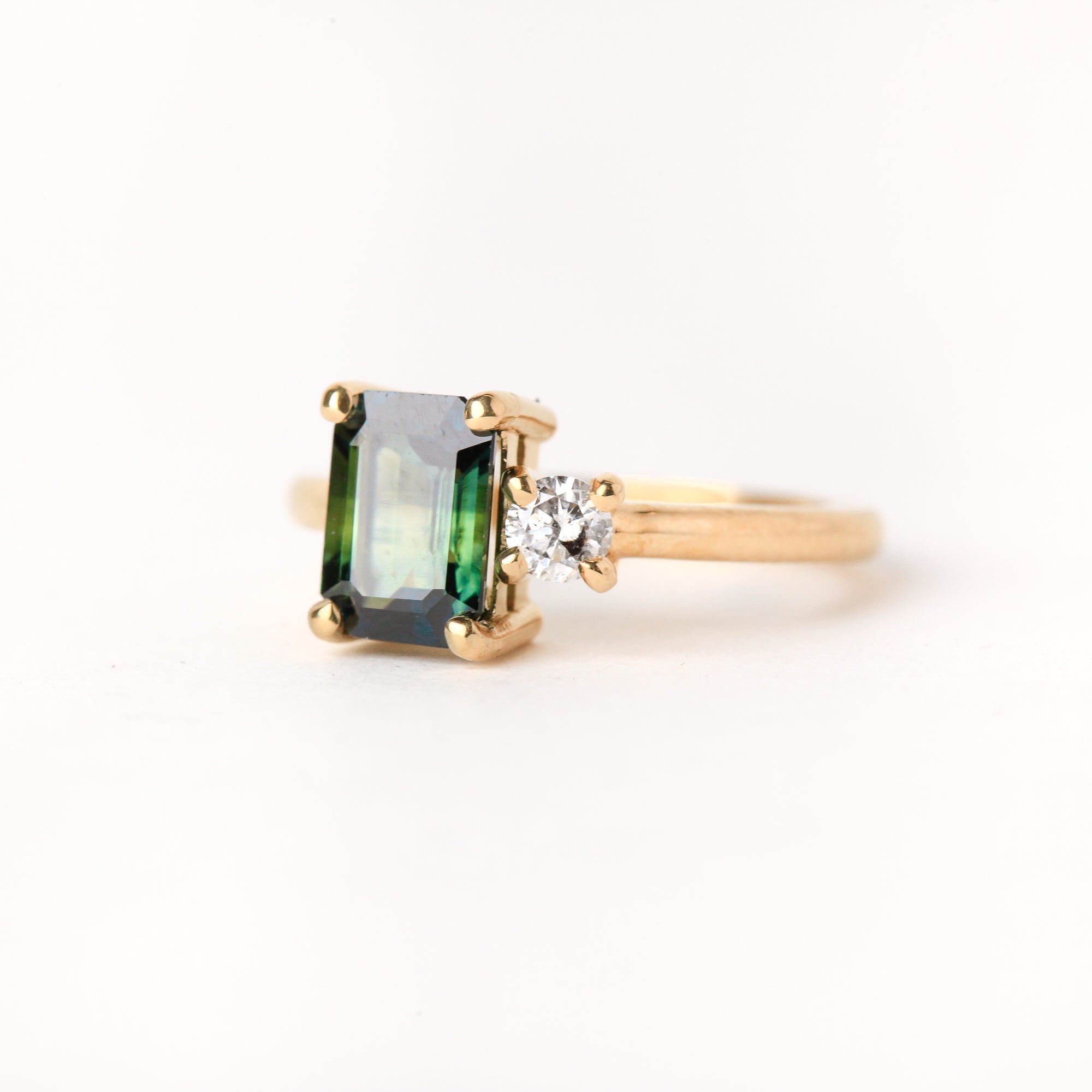 Ethically sourced emerald cut sapphire along side a white diamond. Crafted with recycled, refined gold. Made in Melbourne. 