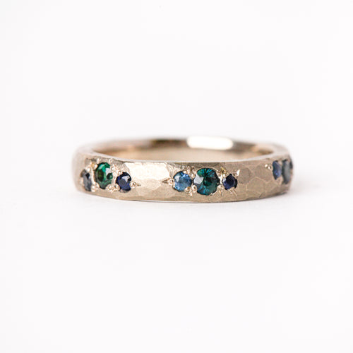 Handmade wedding band in 18 carat white gold, with nine blue and teal ethically sourced Australian sapphires. 