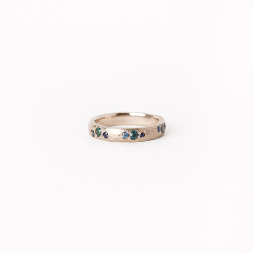 Handmade wedding band in 18 carat white gold, with nine blue and teal ethically sourced Australian sapphires.