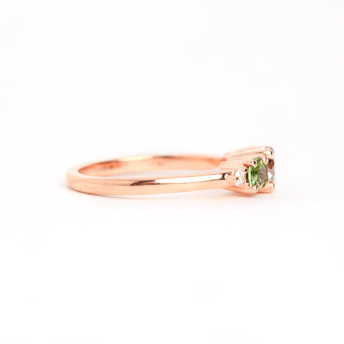  Featured in 18 carat rose gold, a five stone ring with one central round salt and pepper diamond, two round ethically sourced green Australian sapphires, and two round white diamonds. 