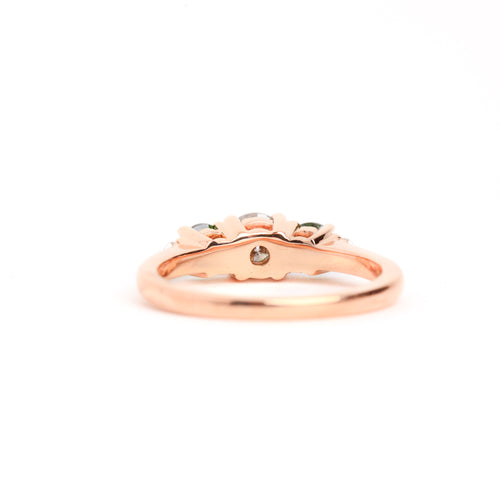  Featured in 18 carat rose gold, a five stone ring with one central round salt and pepper diamond, two round ethically sourced green Australian sapphires, and two round white diamonds. 