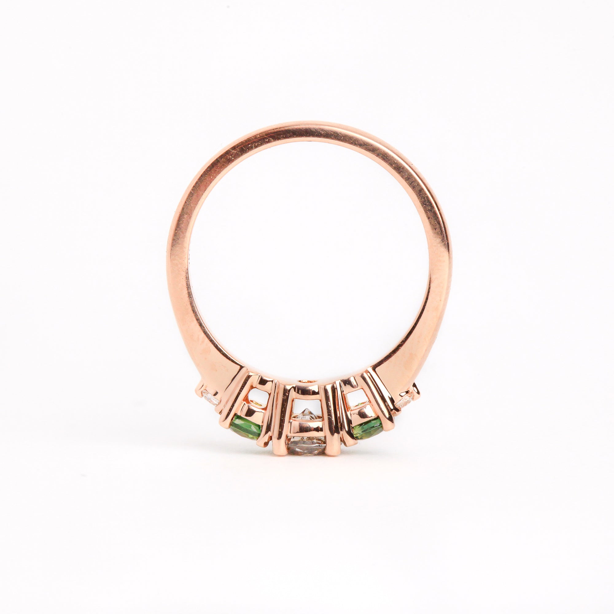  Featured in 18 carat rose gold, a five stone ring with one central round salt and pepper diamond, two round ethically sourced green Australian sapphires, and two round white diamonds. 