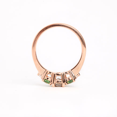  Featured in 18 carat rose gold, a five stone ring with one central round salt and pepper diamond, two round ethically sourced green Australian sapphires, and two round white diamonds. 