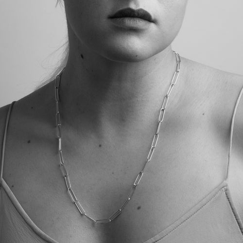 Shown on model gold paperclip chain by Black Finch Jewellery. Long thin gold links connected on as a chain. Bespoke, handmade and crafted in Melbourne.