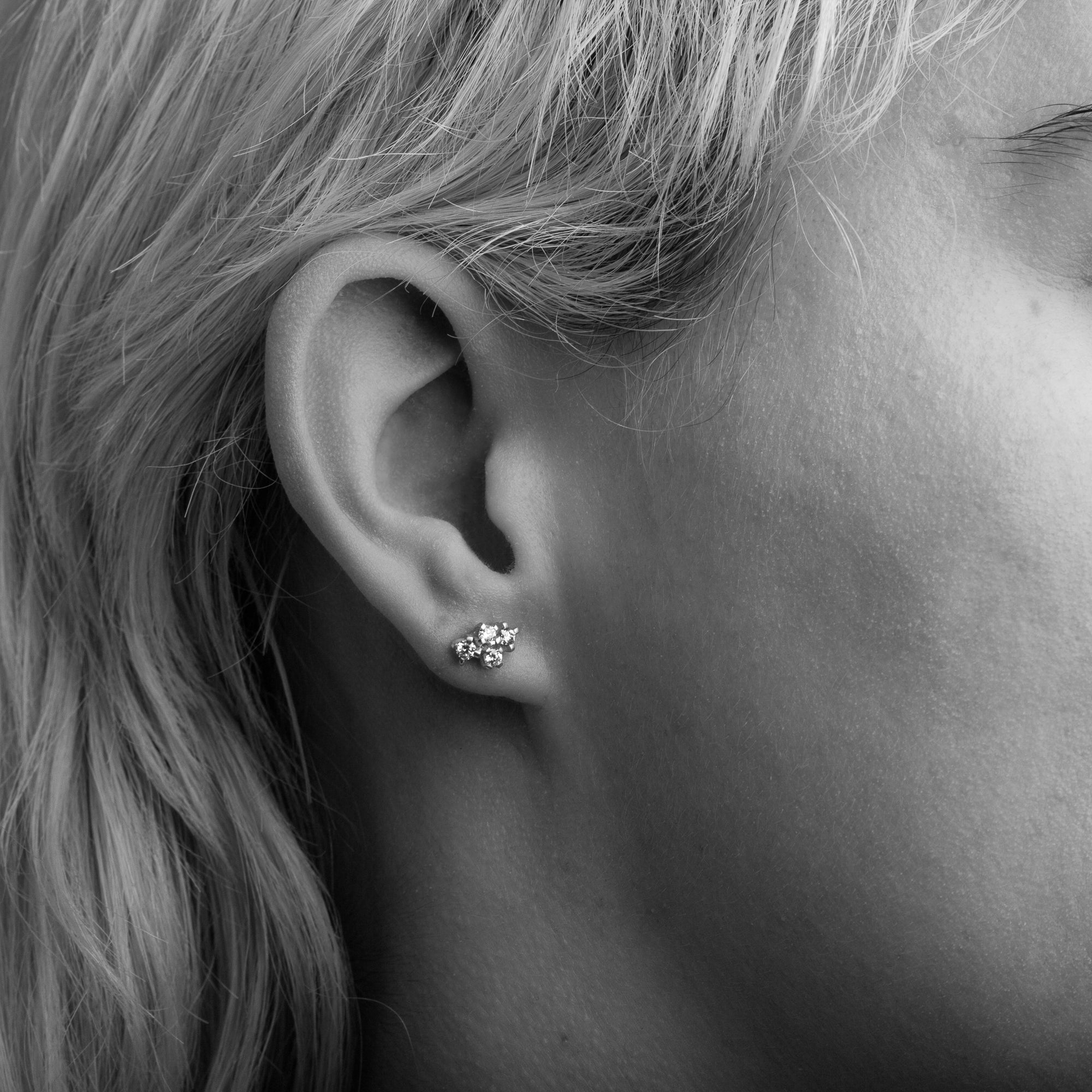 Pair of gold studs featuring four mixed white diamonds. Bespoke and handmade in Melbourne by Black Finch Jewellery. Shown on model.