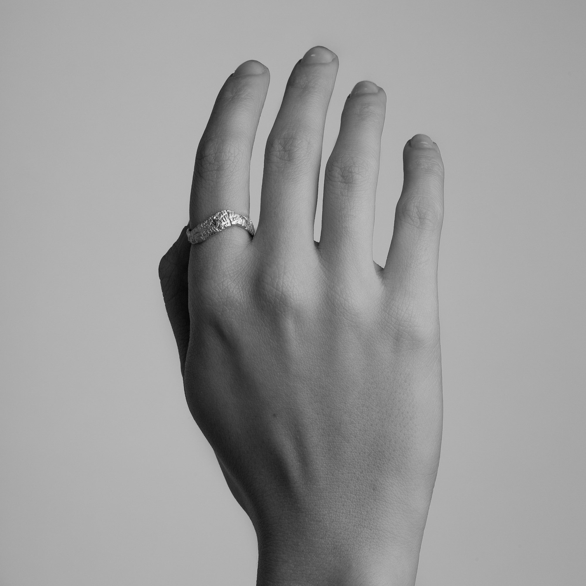 Gold ring featuring wing detailing and blue sapphire. Handmade and bespoke finish. Shown on model.