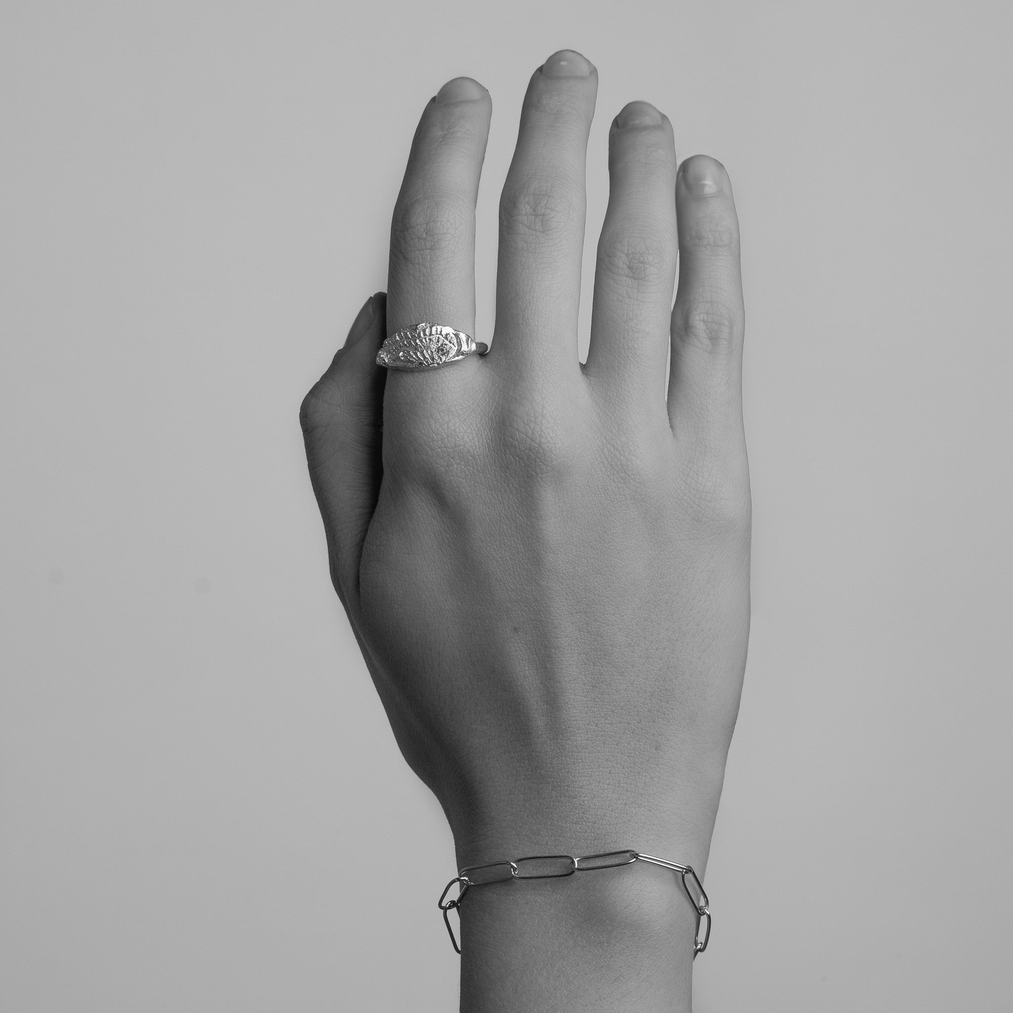 Gold ring featuring wing detailing and blue sapphire. Handmade and bespoke finish. Shown on model.