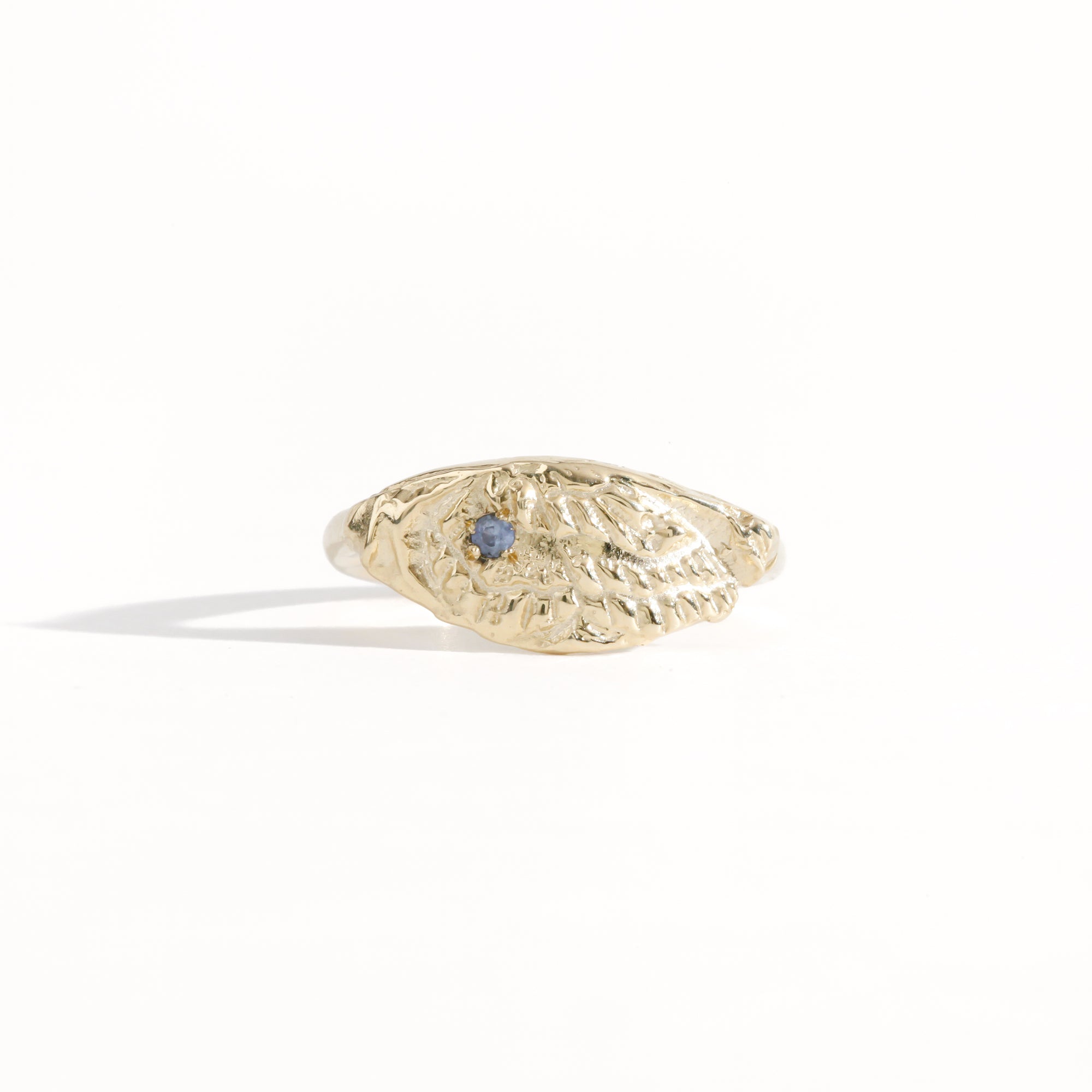 Gold ring featuring wing detailing and blue sapphire. Handmade and bespoke finish.