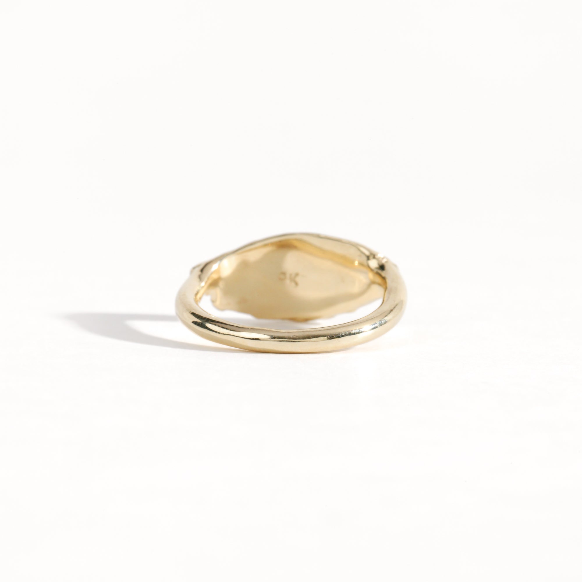 Gold ring featuring wing detailing and blue sapphire. Handmade and bespoke finish.