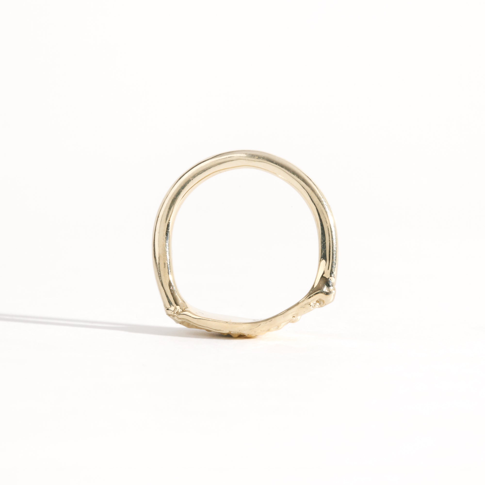 Gold ring featuring wing detailing and blue sapphire. Handmade and bespoke finish.