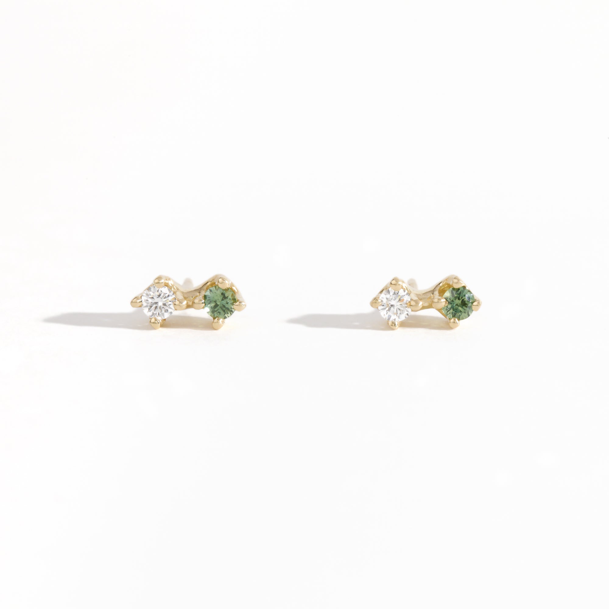 Pair of yellow gold studs featuring white diamond and sea foam green sapphires. Bespoke, handmade jewellery.