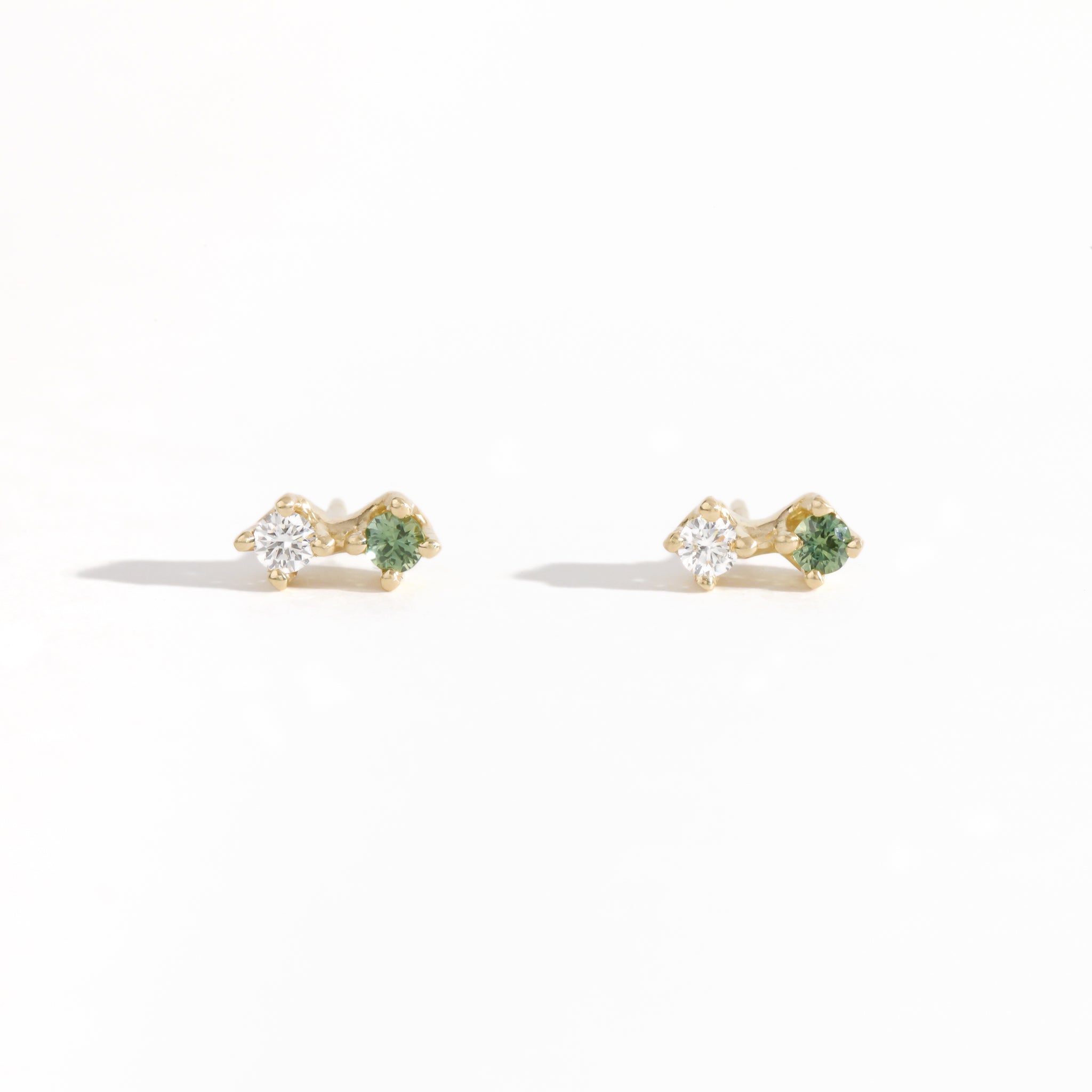 Pair of yellow gold studs featuring white diamond and sea foam green sapphires. Bespoke, handmade jewellery.