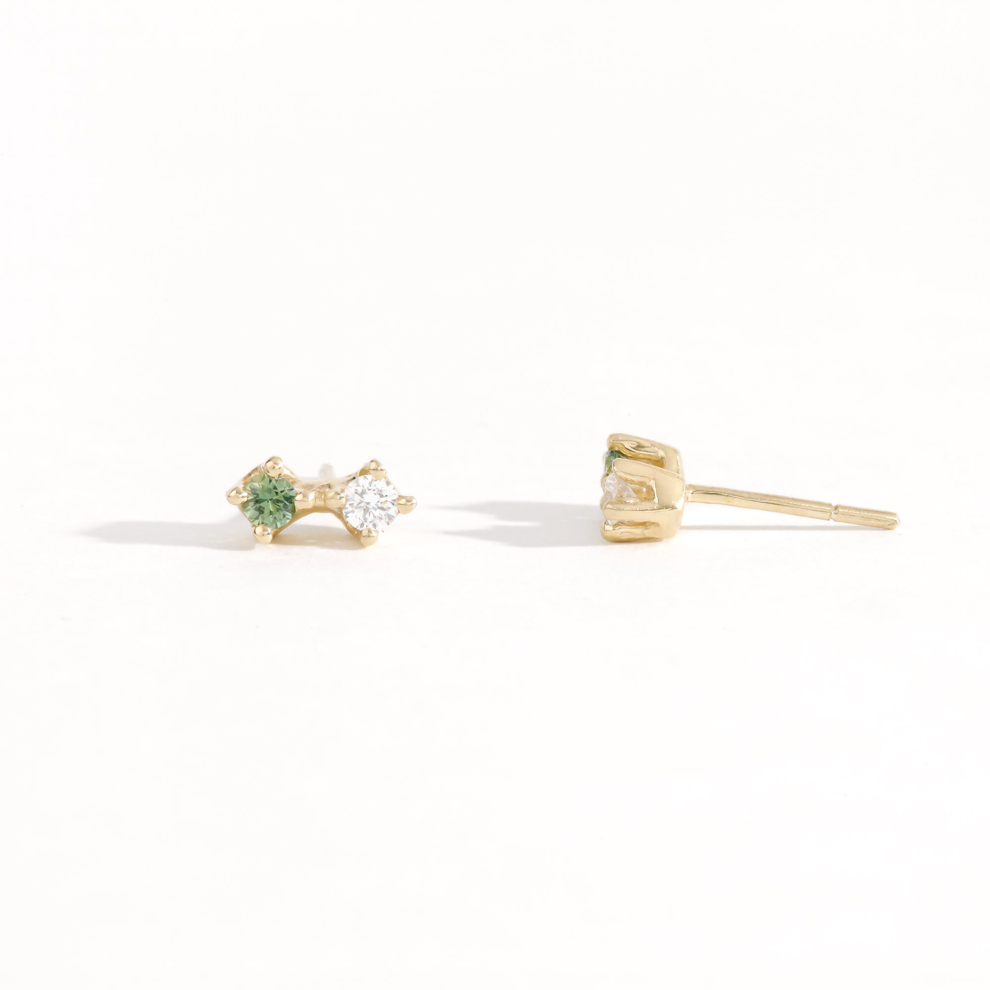 Pair of yellow gold studs featuring white diamond and sea foam green sapphires. Bespoke, handmade jewellery.