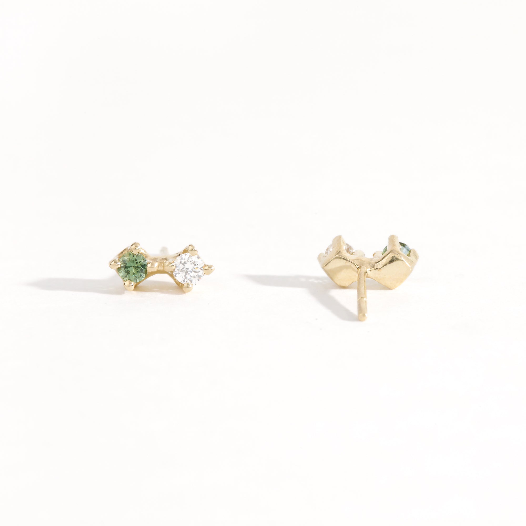Pair of yellow gold studs featuring white diamond and sea foam green sapphires. Bespoke, handmade jewellery.