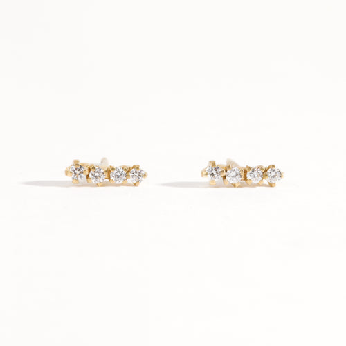 A pair of earring studs crafted with 9ct recycled refined yellow gold with a row of four diamonds by Black Finch Jewellery