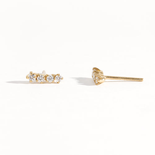A pair of earring studs crafted with 9ct recycled refined yellow gold with a row of four diamonds by Black Finch Jewellery