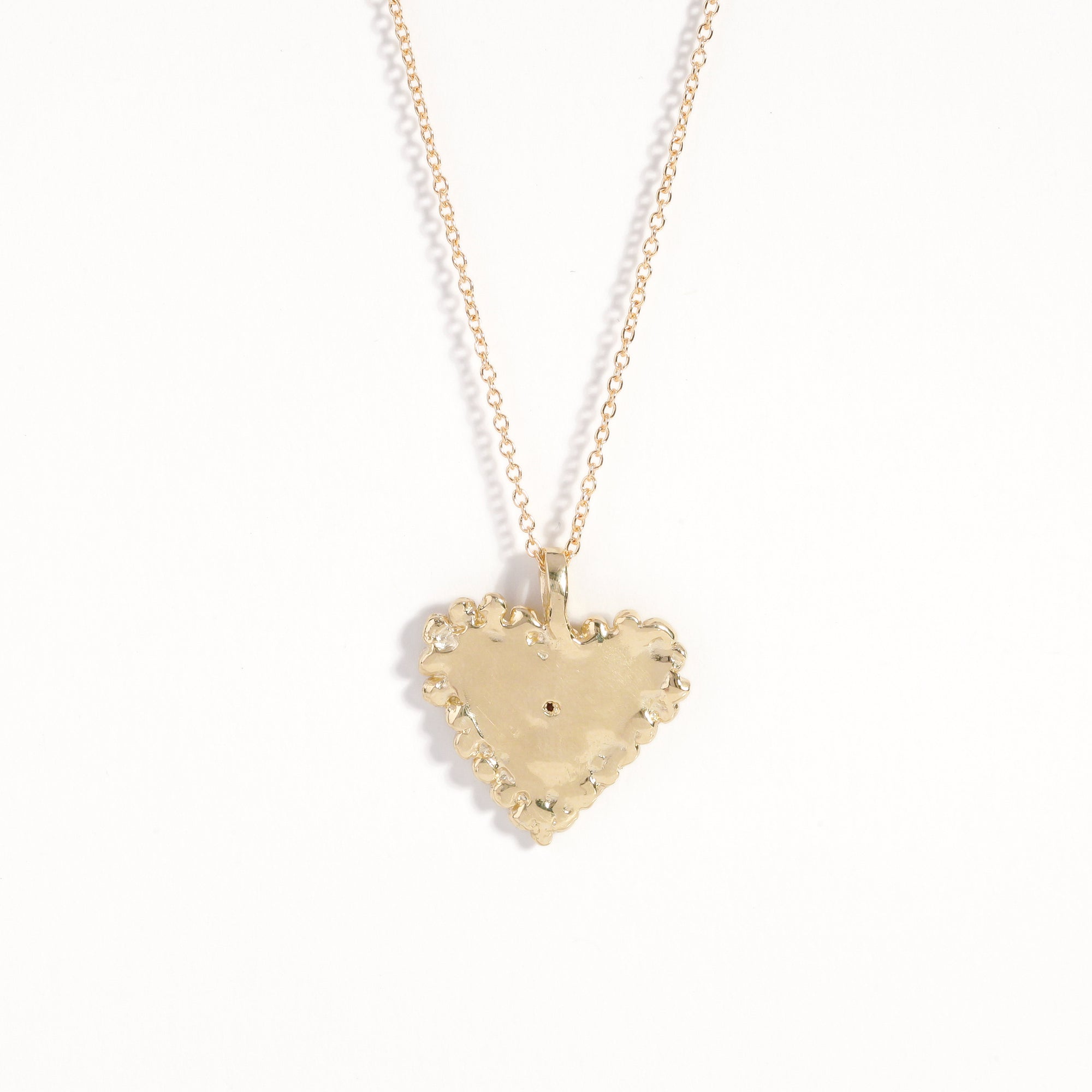 Handmade 9 carat yellow gold heart pendant set with a ruby in centre of eye detail on 9 carat yellow gold chain.