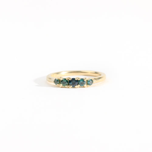 A bespoke handcrafted five stone ring in yellow gold with ethically sourced Australian teal sapphires